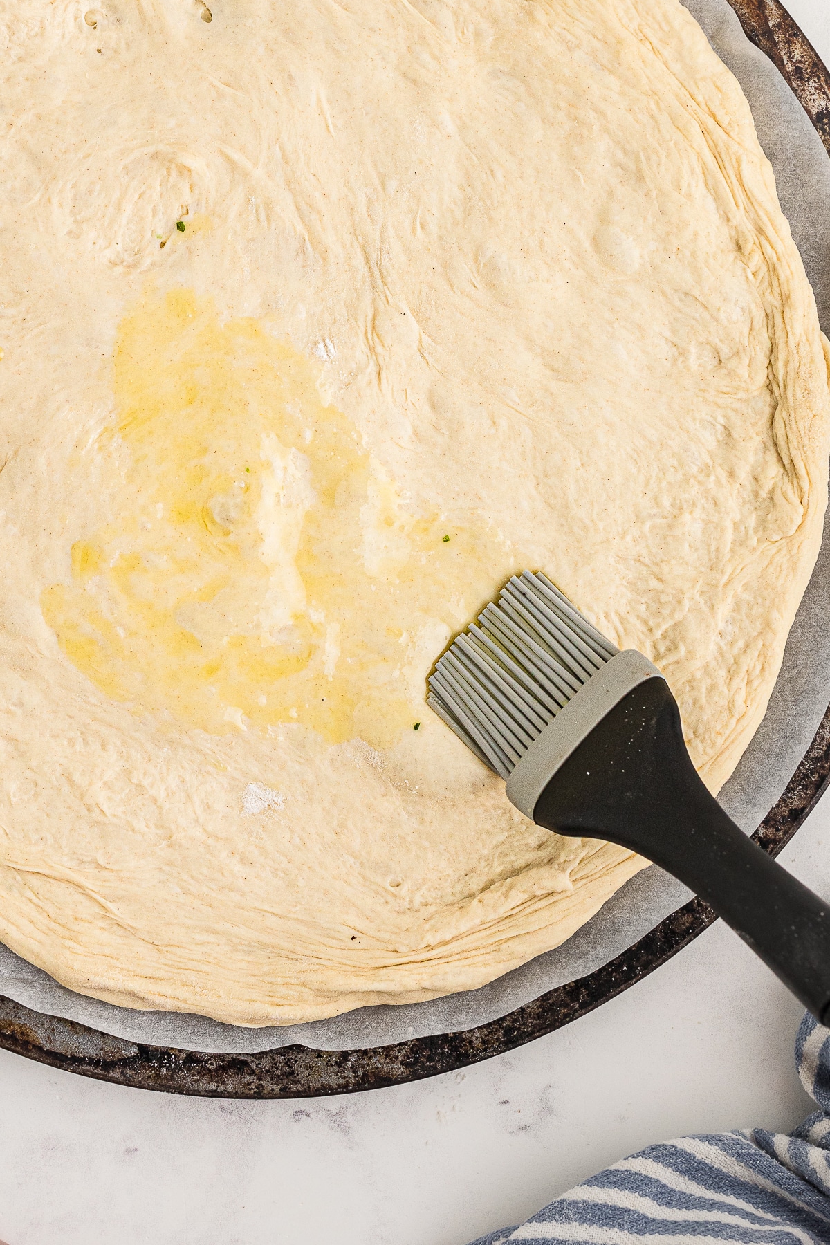 olive oil being brushed on Neapolitan Pizza Dough Recipe