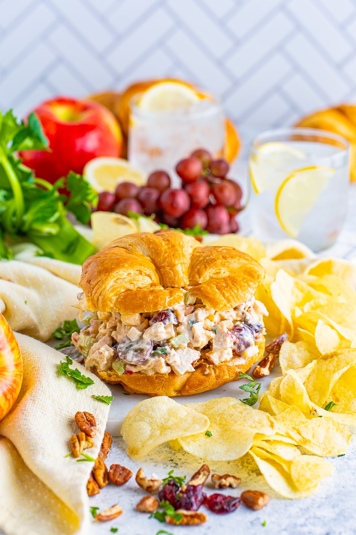 Chicken Salad Recipe on a sandwich surrounded by ingredients