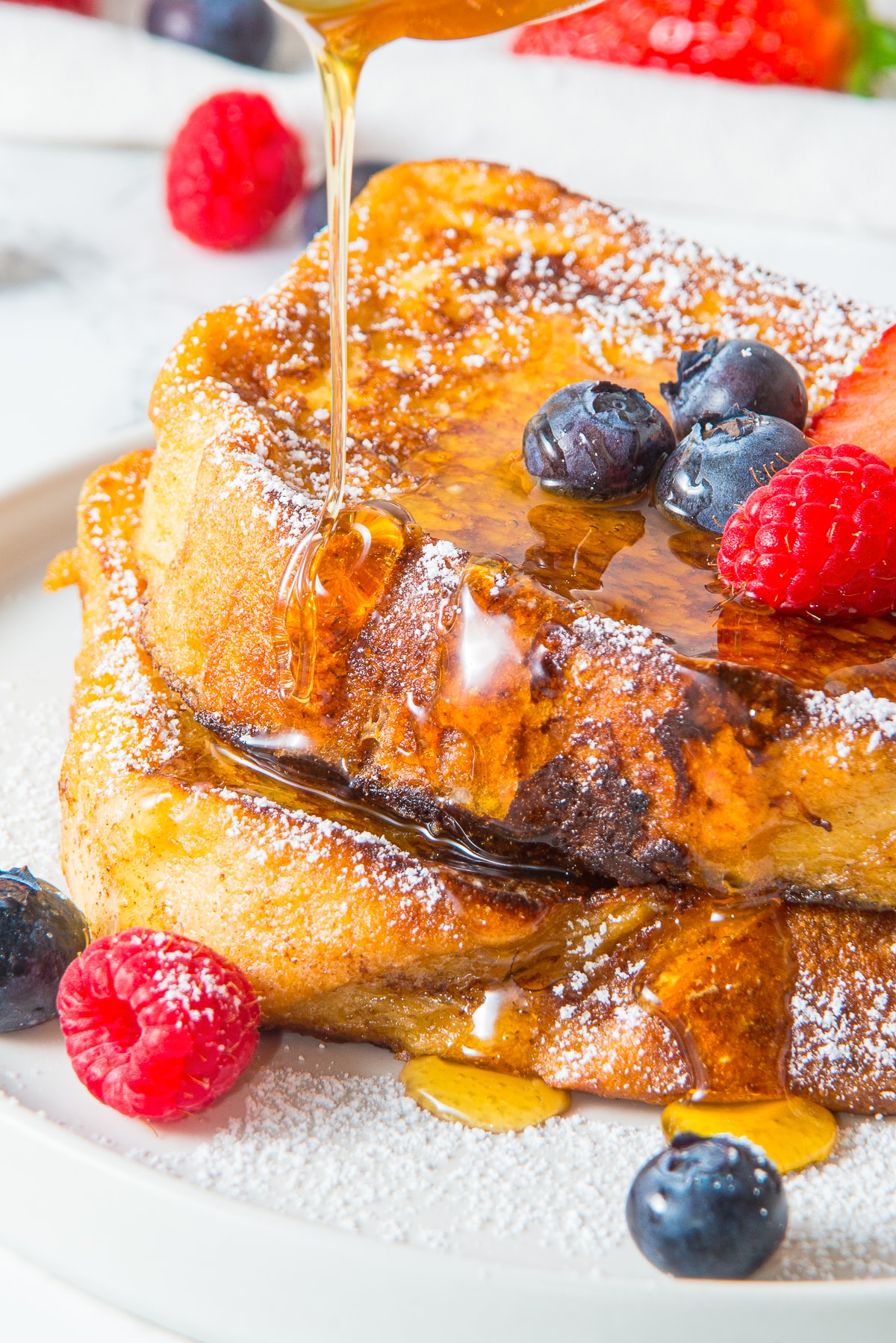 up close image of maple syrup being poured on French toast recipe