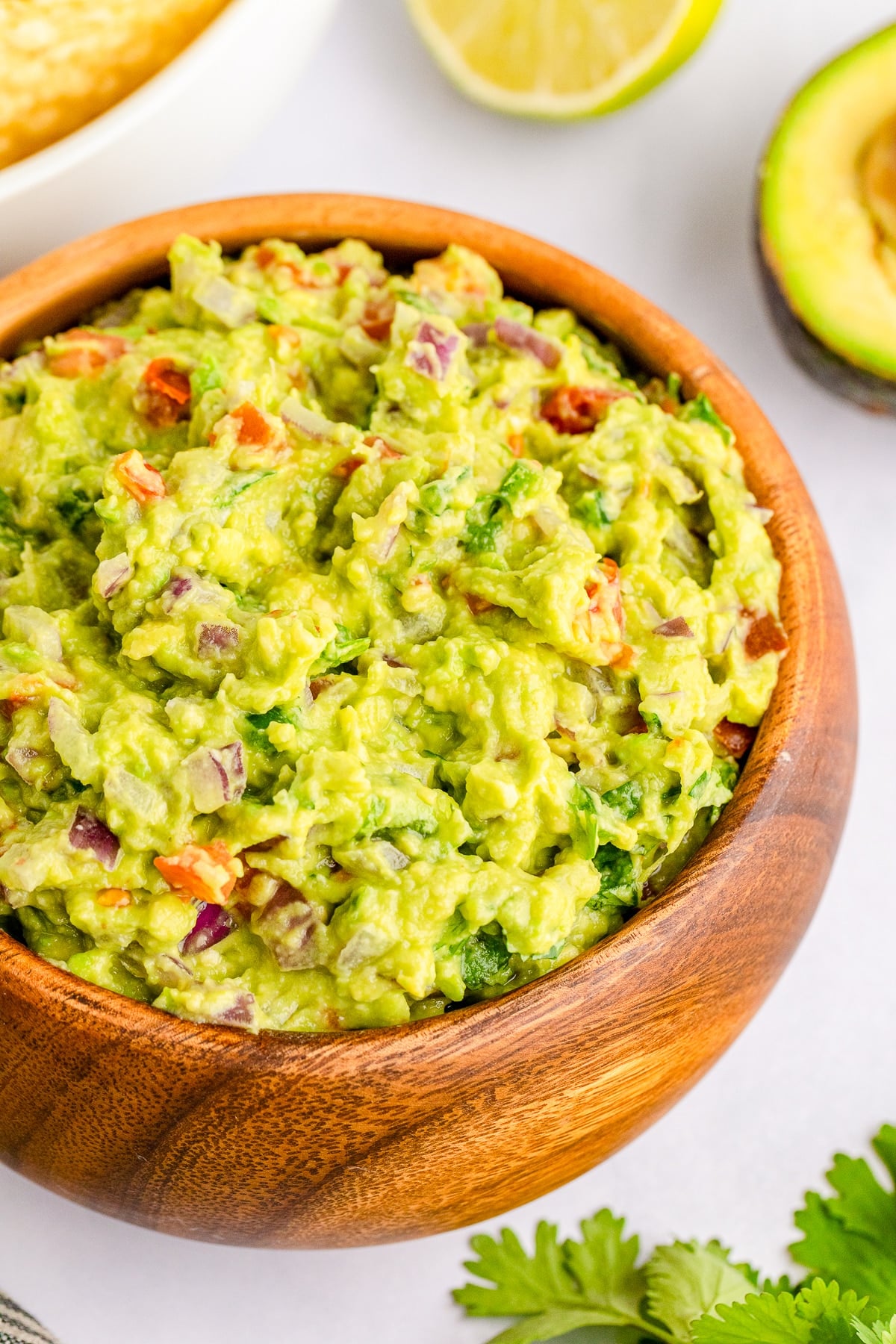 up close overhead image of guacamole in wooden bowl
