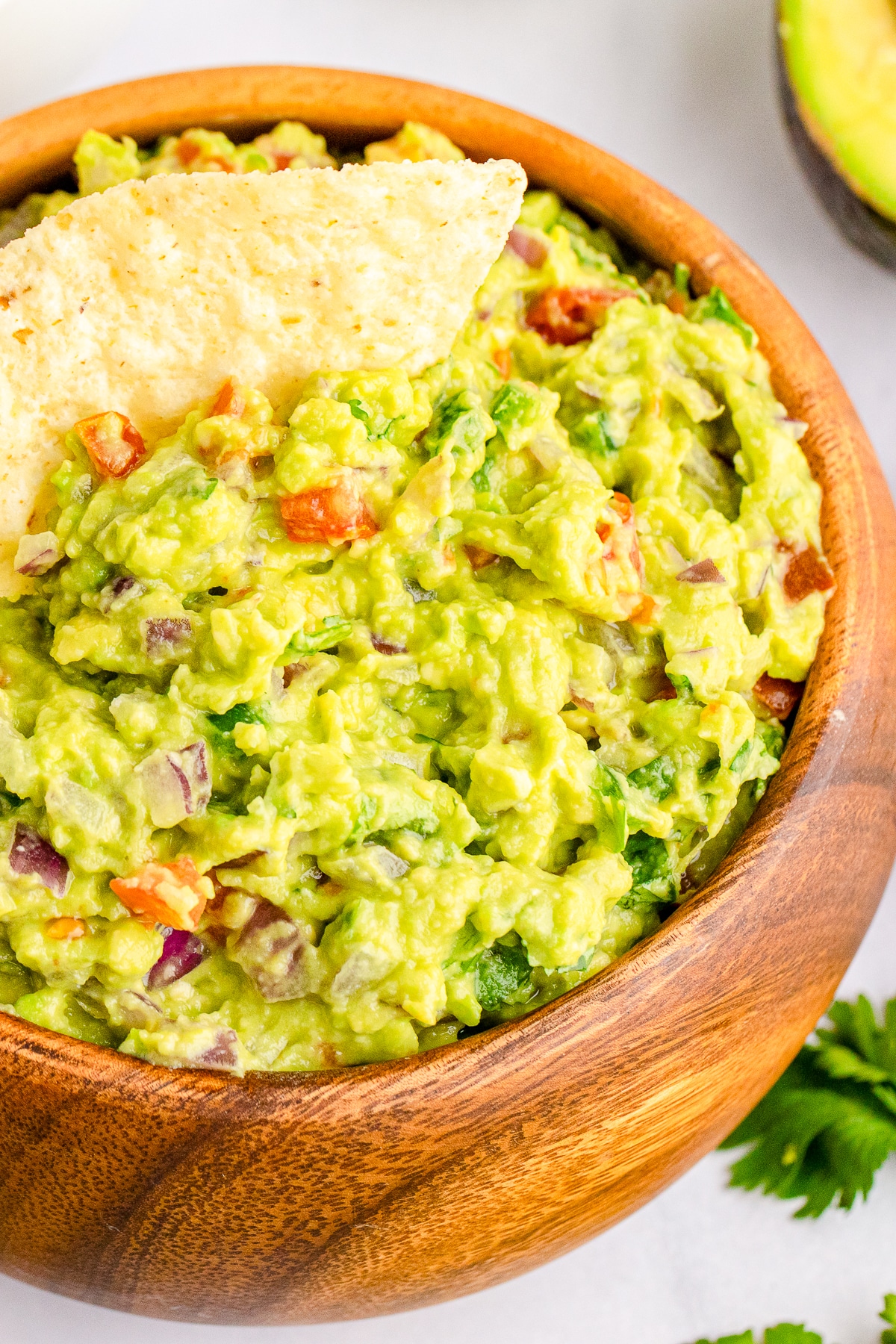 close up of guacamole in bowl with a chip in it