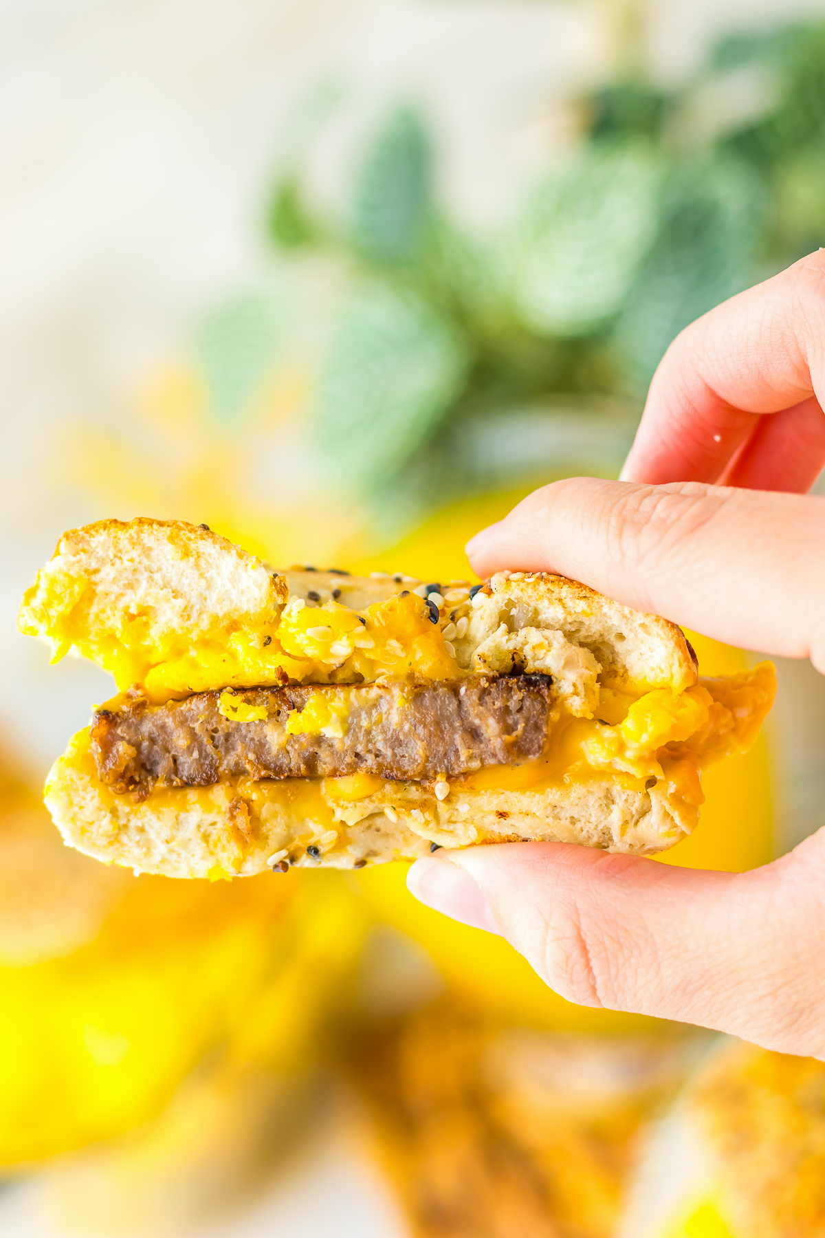 a hand holding up Breakfast Sliders in air with a bite taken out