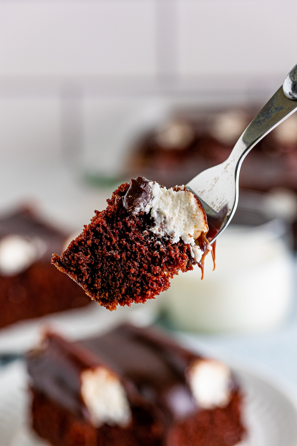 a fork holding up a bite of Bumpy Cake in air