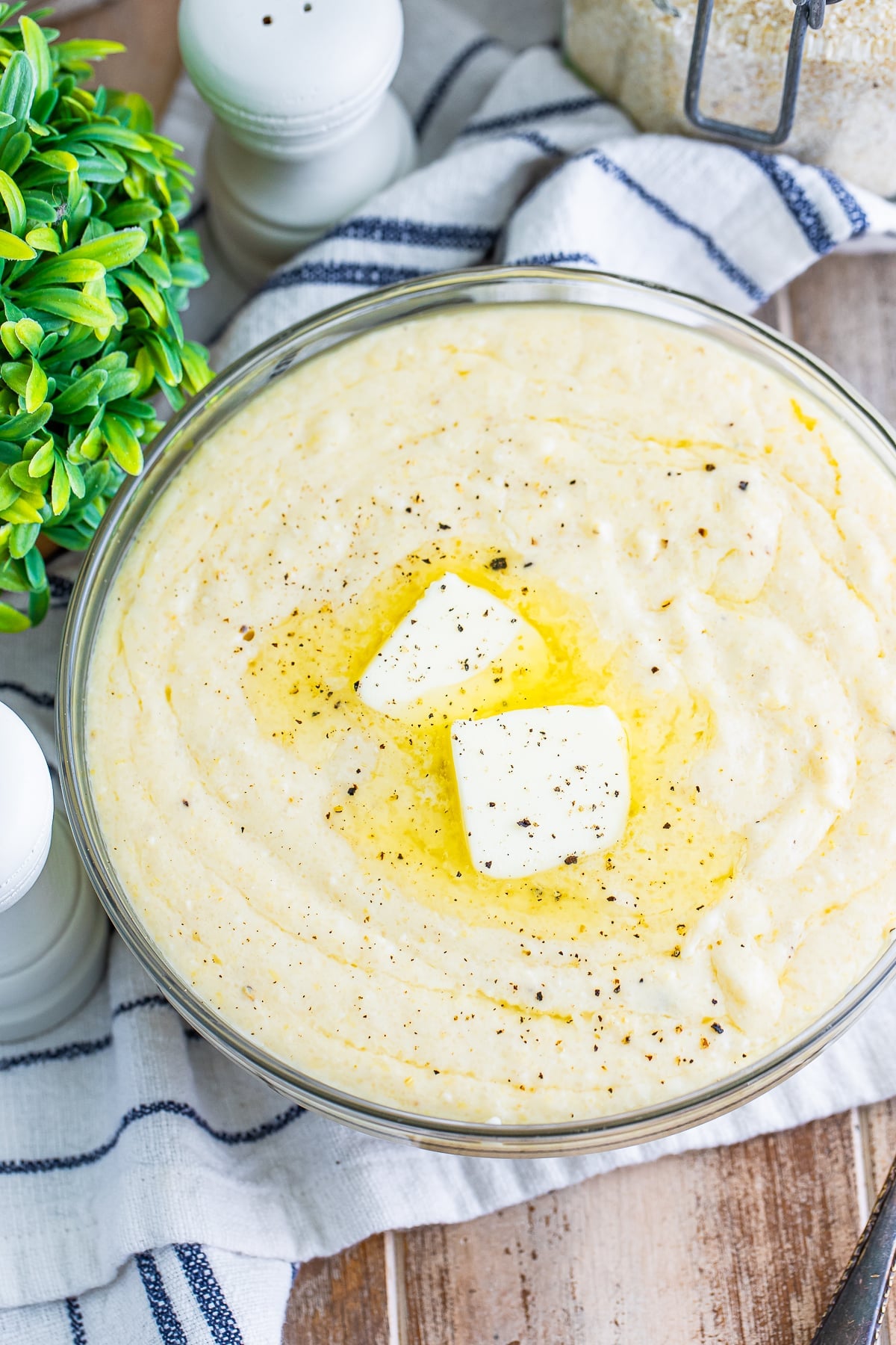 overhead image of grits in a clear bowl with butter