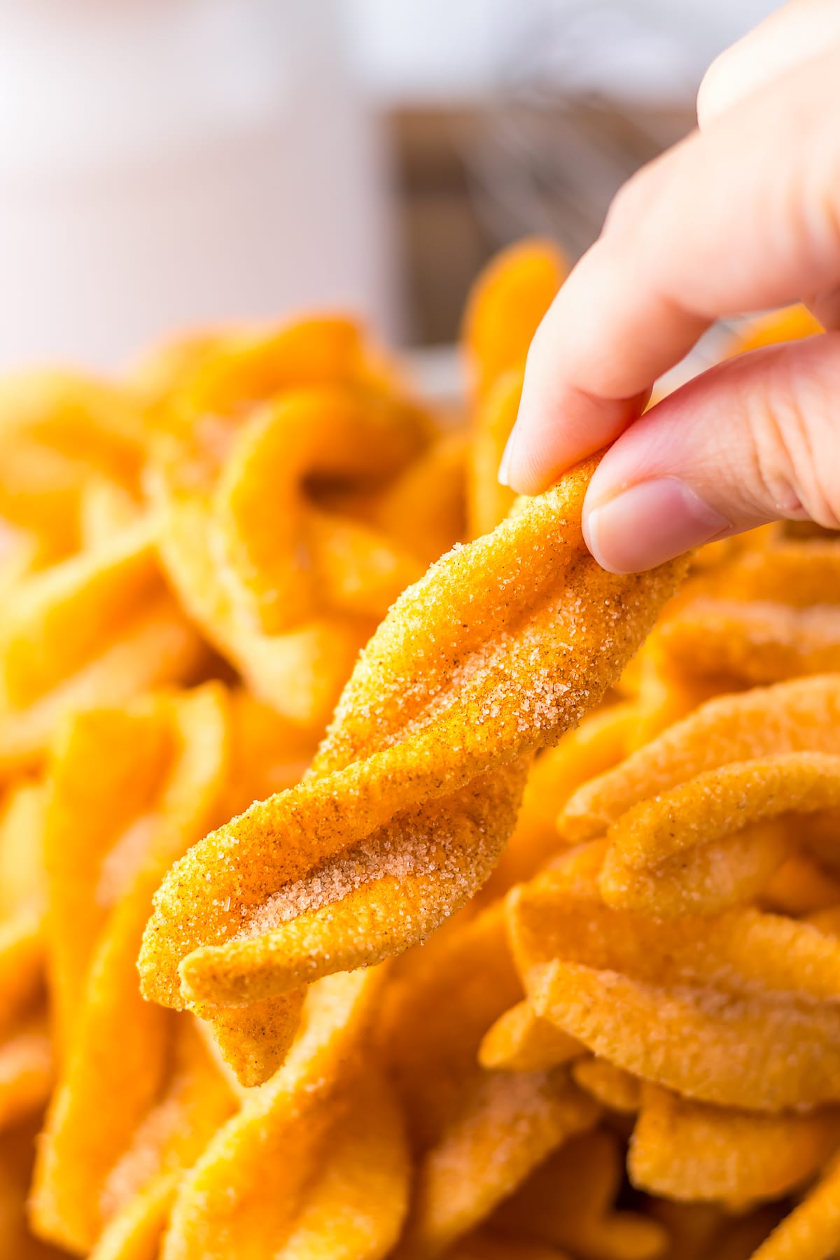 a hand holding up Cinnamon Twists in air