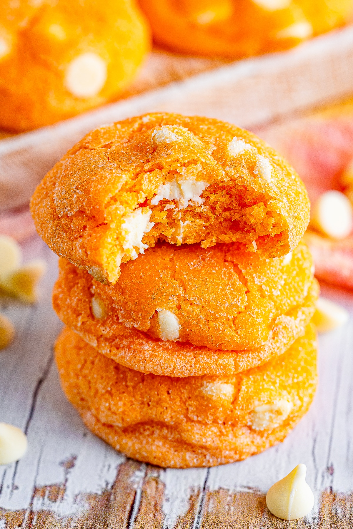 three Orange Creamsicle Cookies stacked, the one on top has a bite taken out