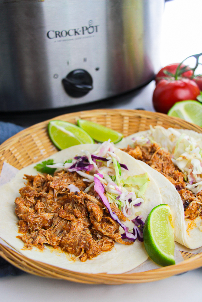 farther away image of Crockpot Pulled Chicken Tacos served in a wooden basket