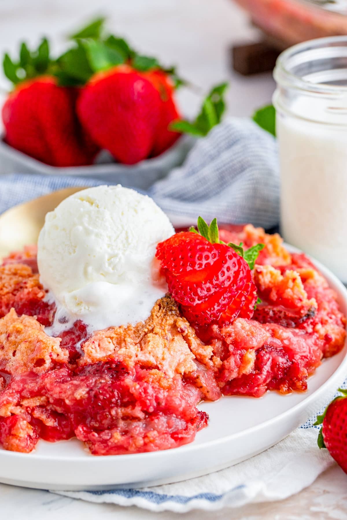 Strawberry Dump Cake served in a plate with ice cream