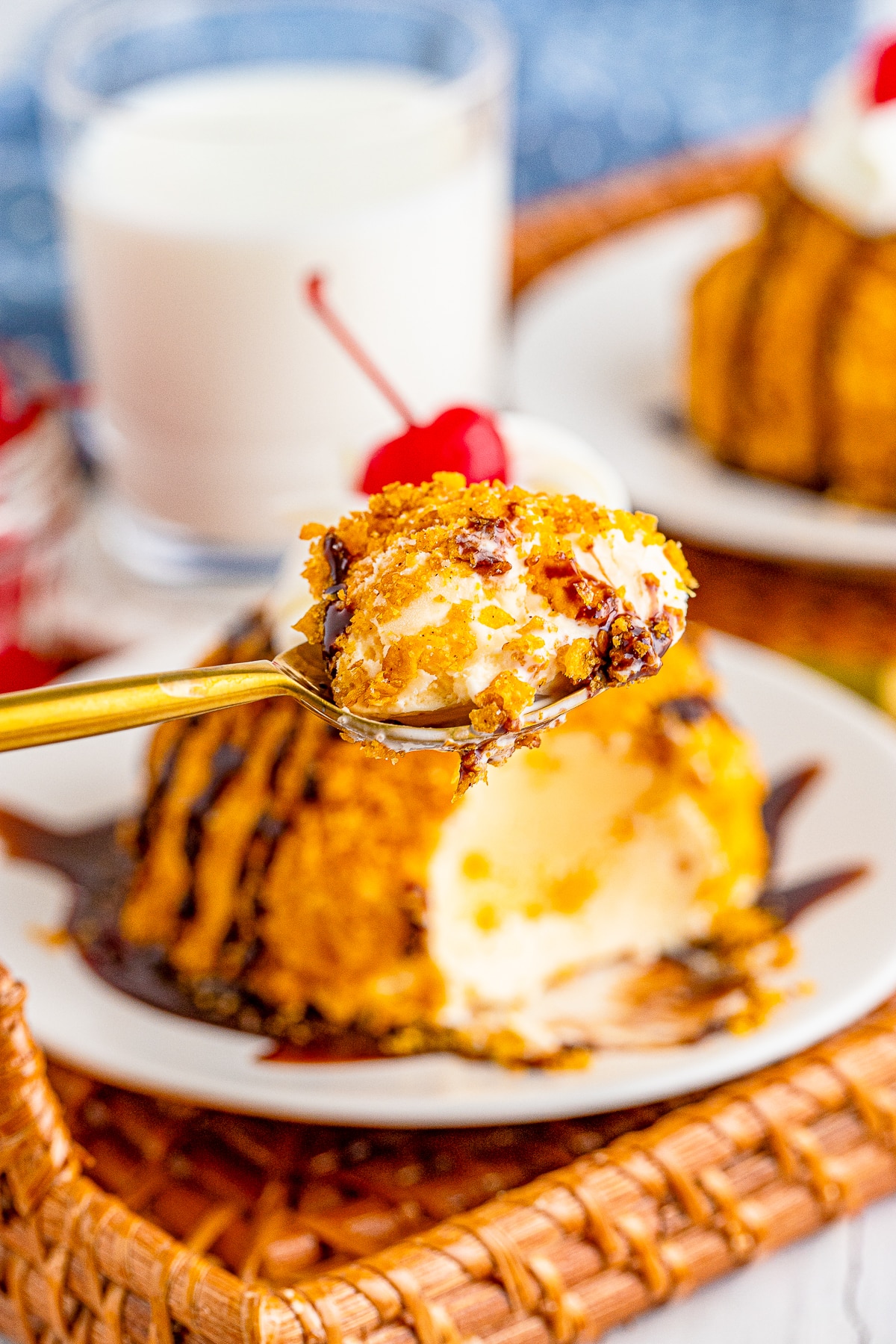 a spoon holding up a bite of fried ice cream in air