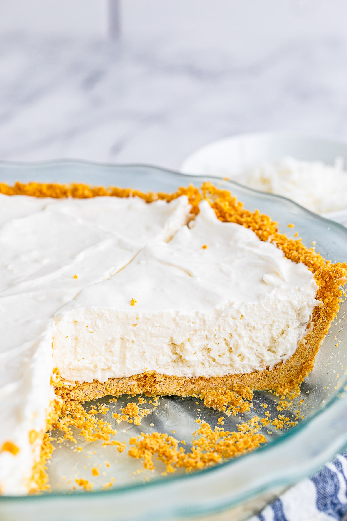 coconut cream pie in baking dish with slices taken out