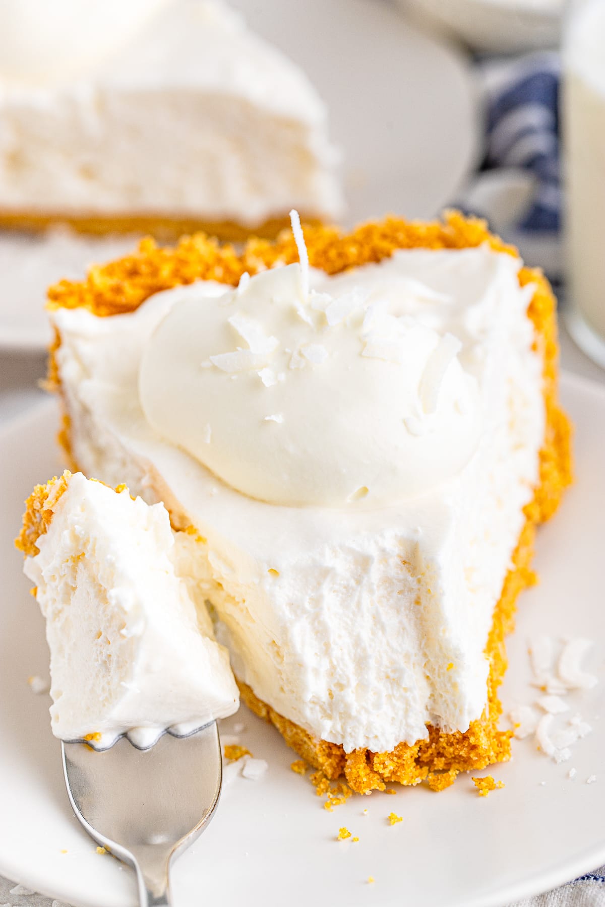 coconut cream pie on a plate with a bite taken out