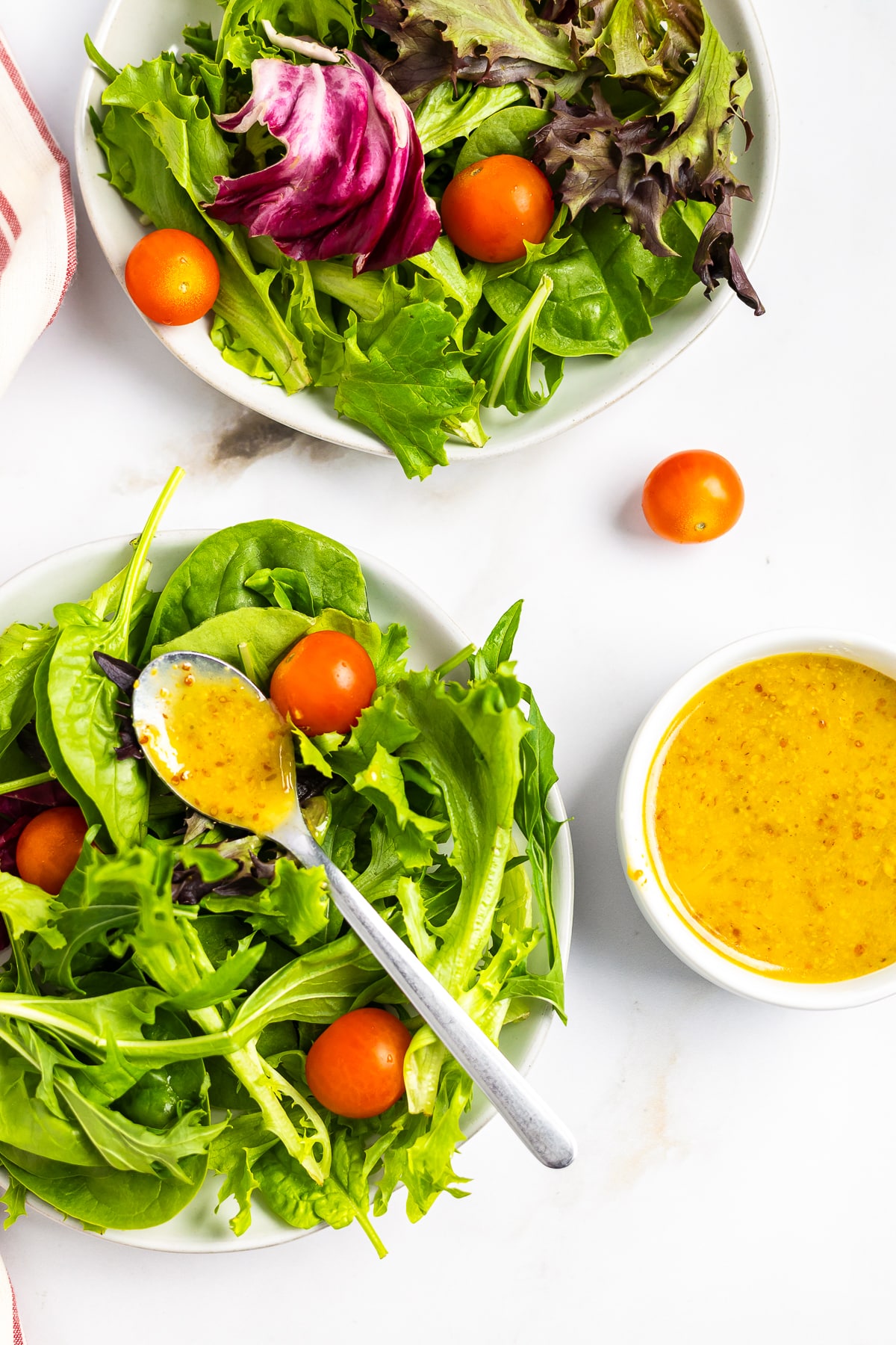 a spoon with Honey Mustard Dressing Recipe on it on top of a small salad