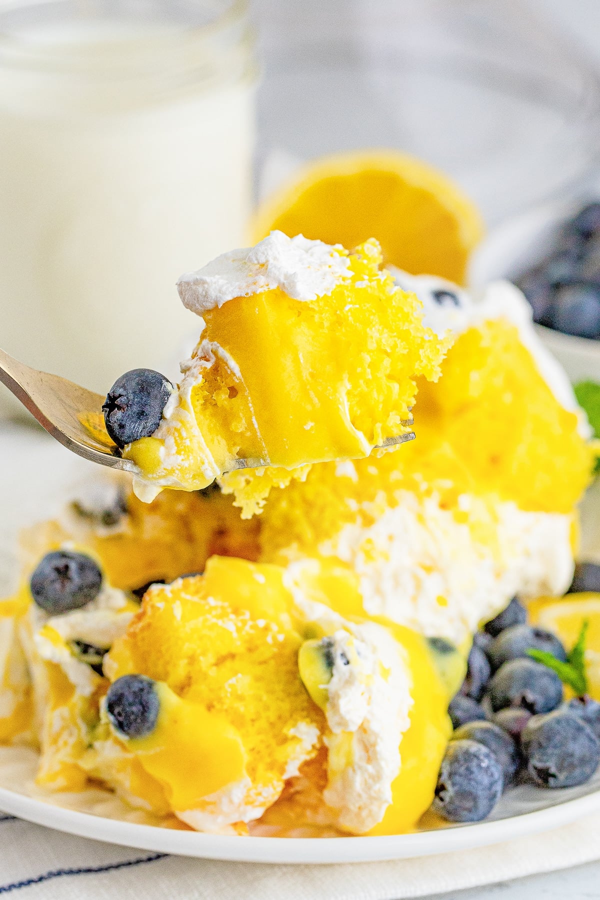 a fork holding up a bite of Blueberry Trifle in air