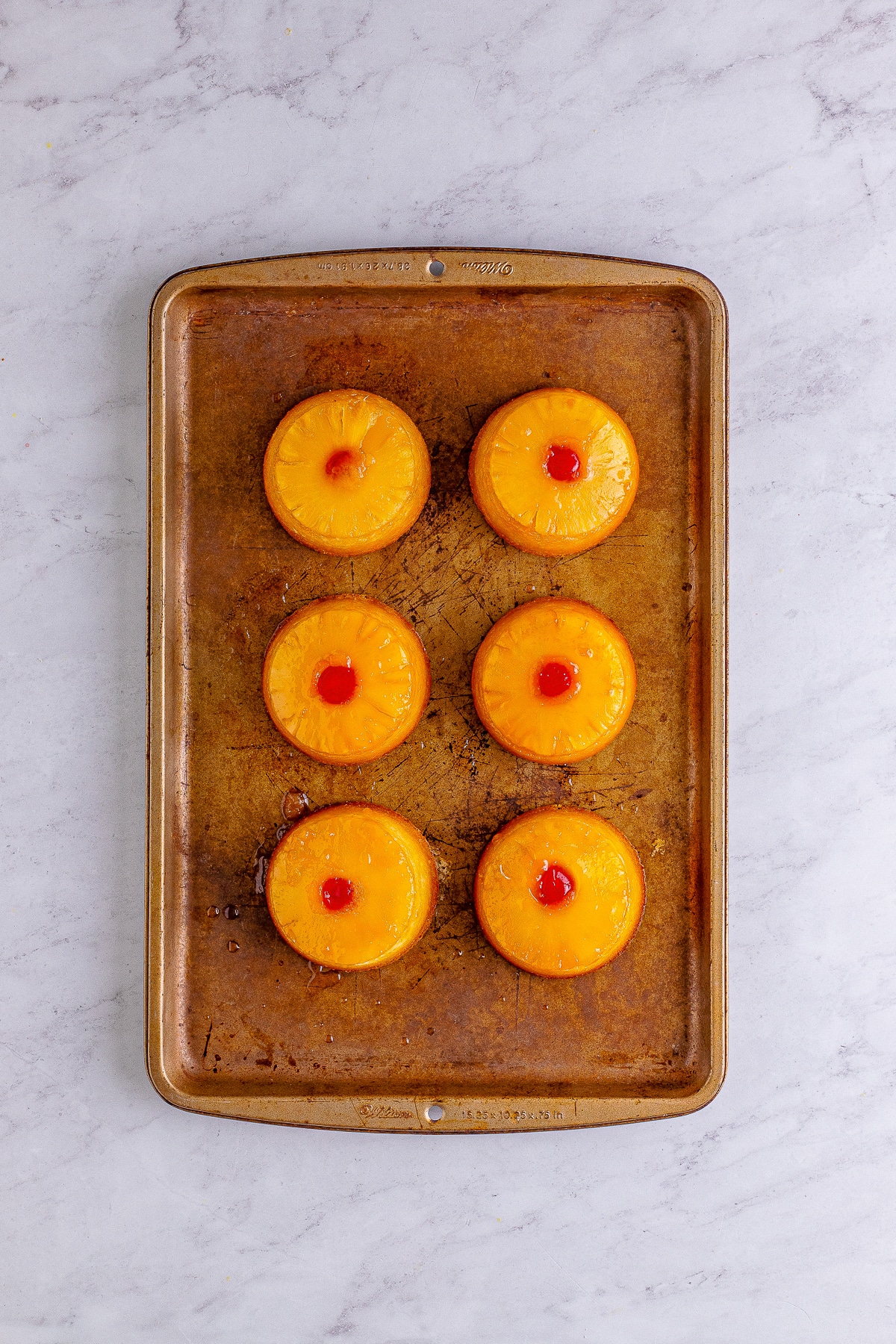 finished Mini Pineapple Upside Down Cakes on sheet tray