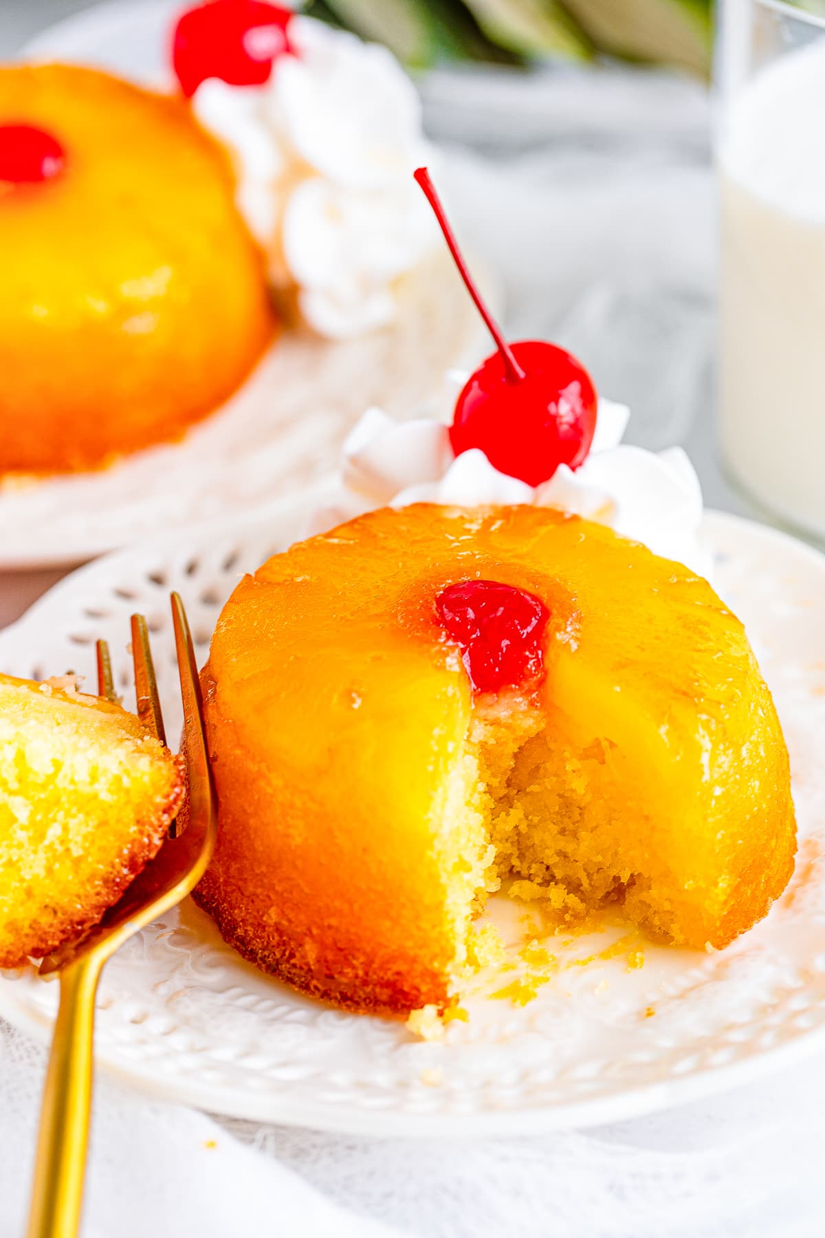 one Mini Pineapple Upside Down Cakes on a white plate with a bite taken out