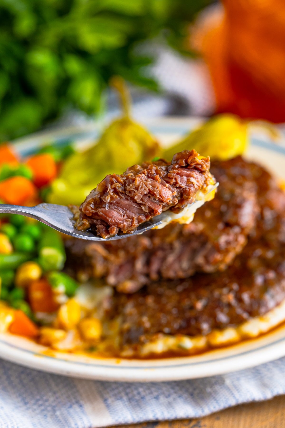 a fork holding up a bite of Beef Cubed Steaks in air