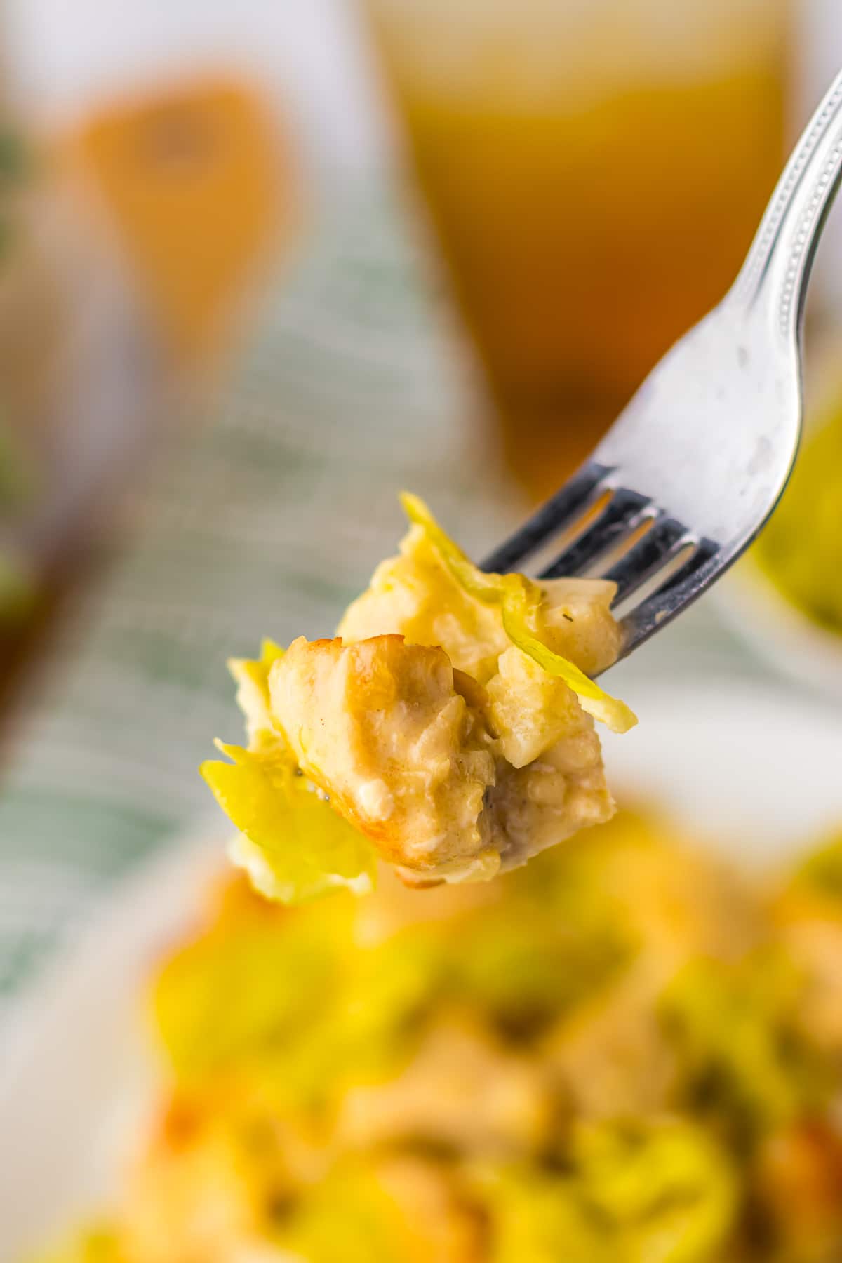a fork holding up a bite of Pepperoncini Chicken in air