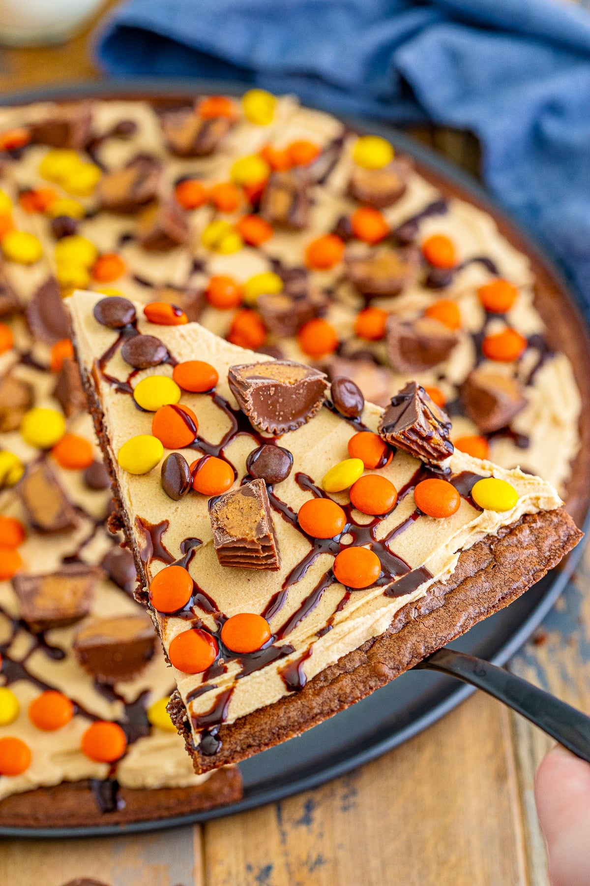 a cake server holding up a slice of Dessert Pizza in air