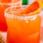 A salty dog cocktail with a salted rim and a fresh grapefruit slice garnish over ice in a rocks glass.