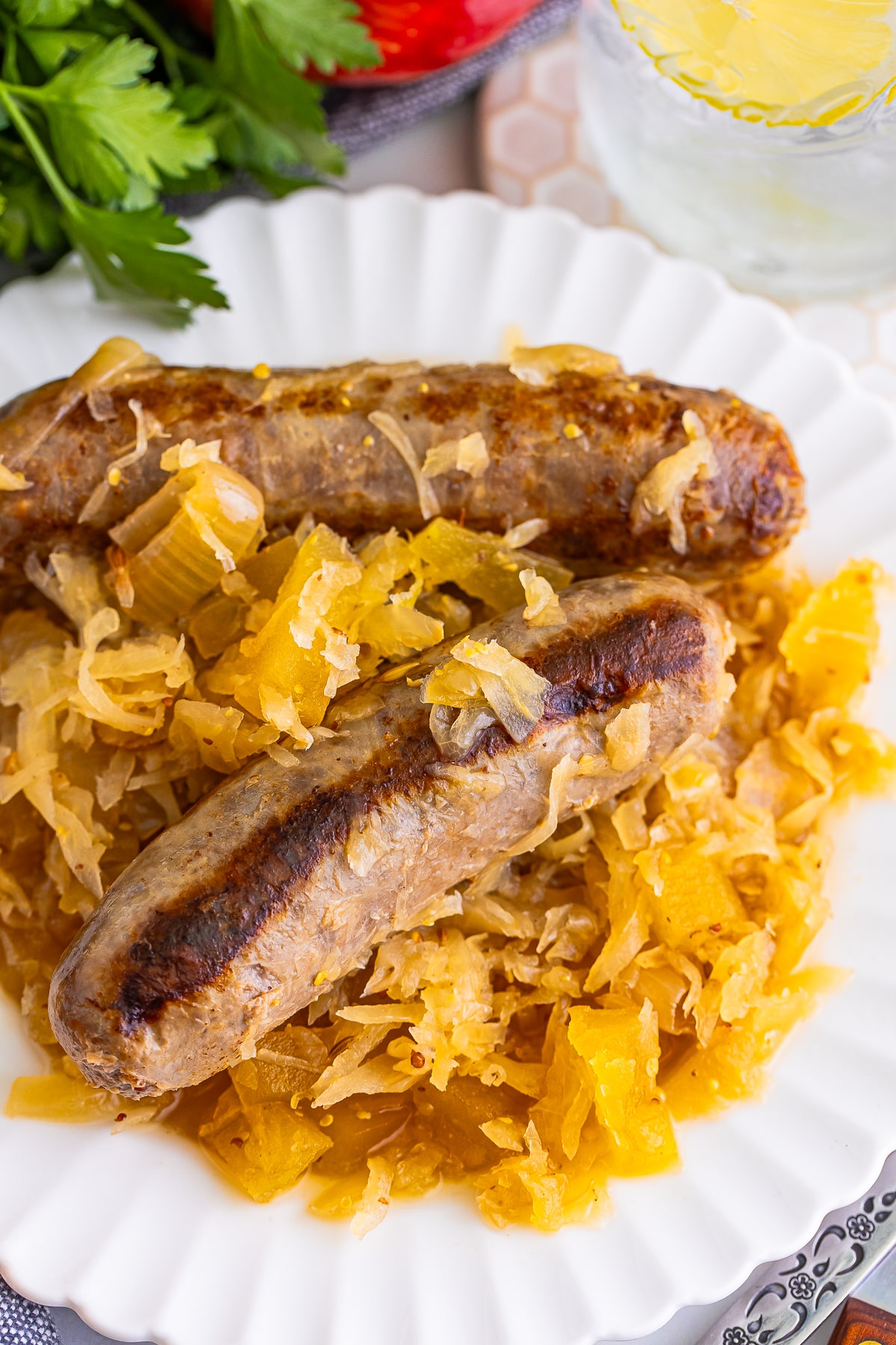 up close image of Brats and Sauerkraut on white plate