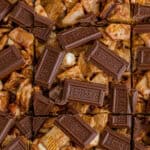 Golden grahams smores bars cut into squares and topped with Hershey's chocolate pieces.