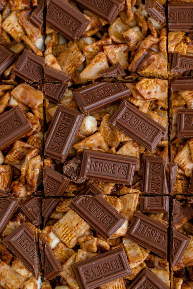Golden grahams smores bars cut into squares and topped with Hershey's chocolate pieces.