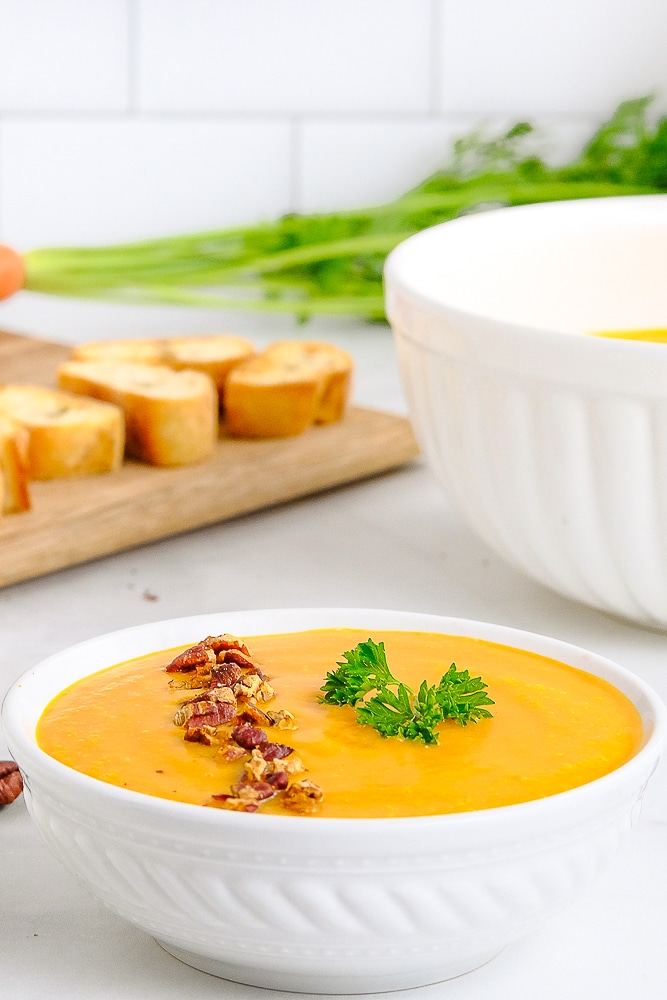 finished carrot soup in bowl with garnishes