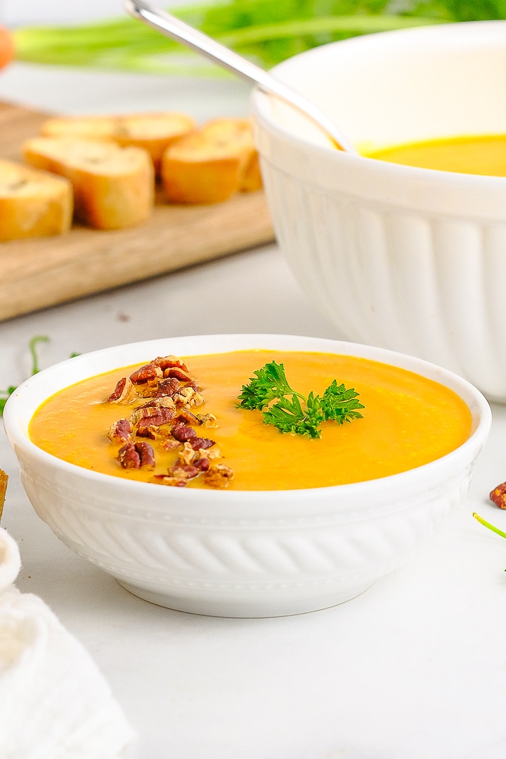 straight on image of carrot soup served in a white bowl
