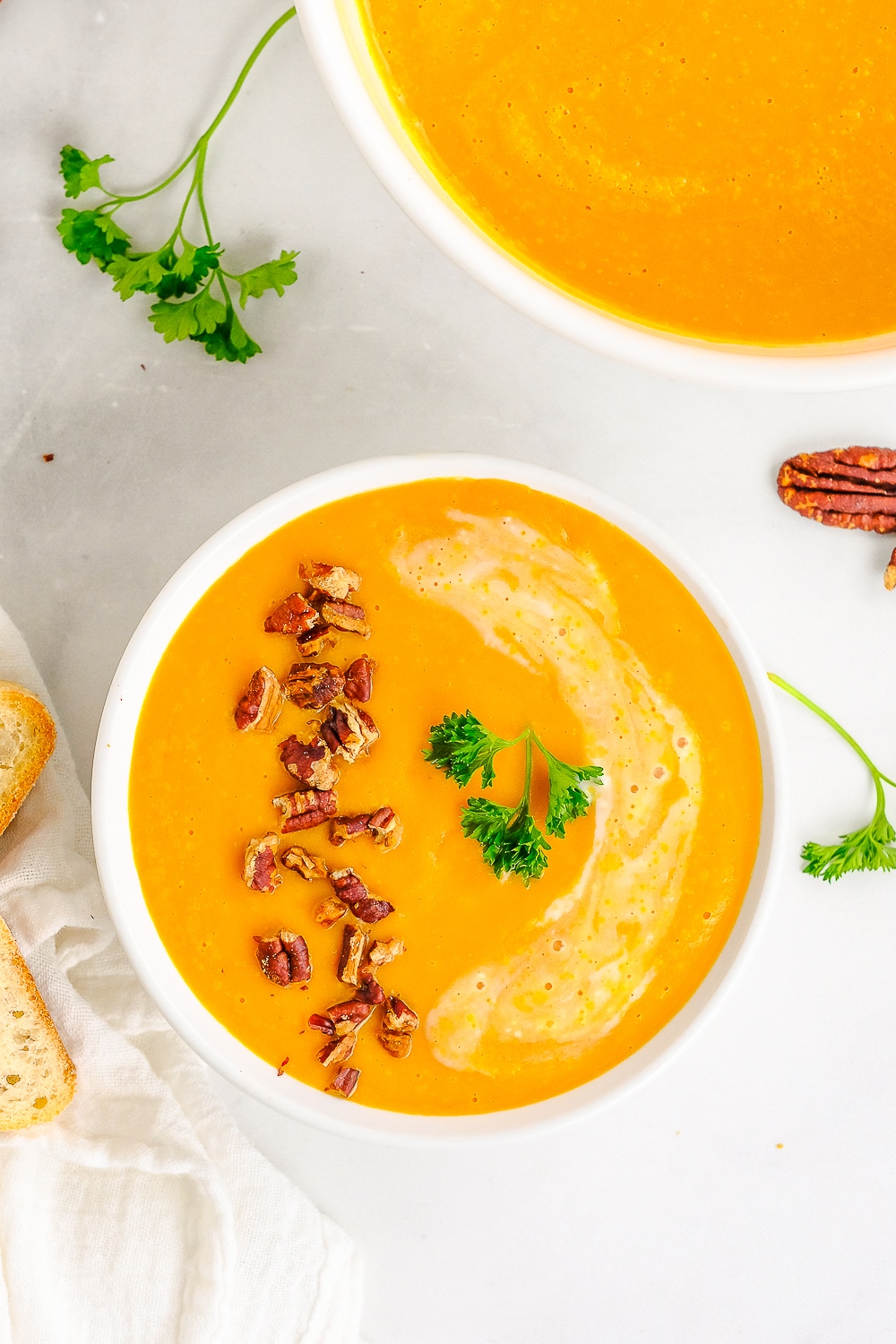 overhead image of carrot soup in white bowl