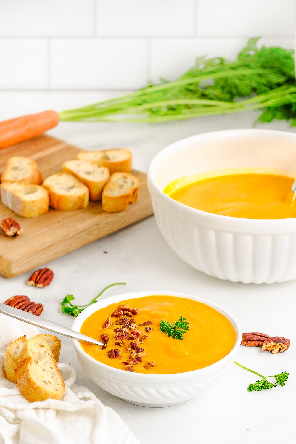 far away image of carrot soup in bowl with bread