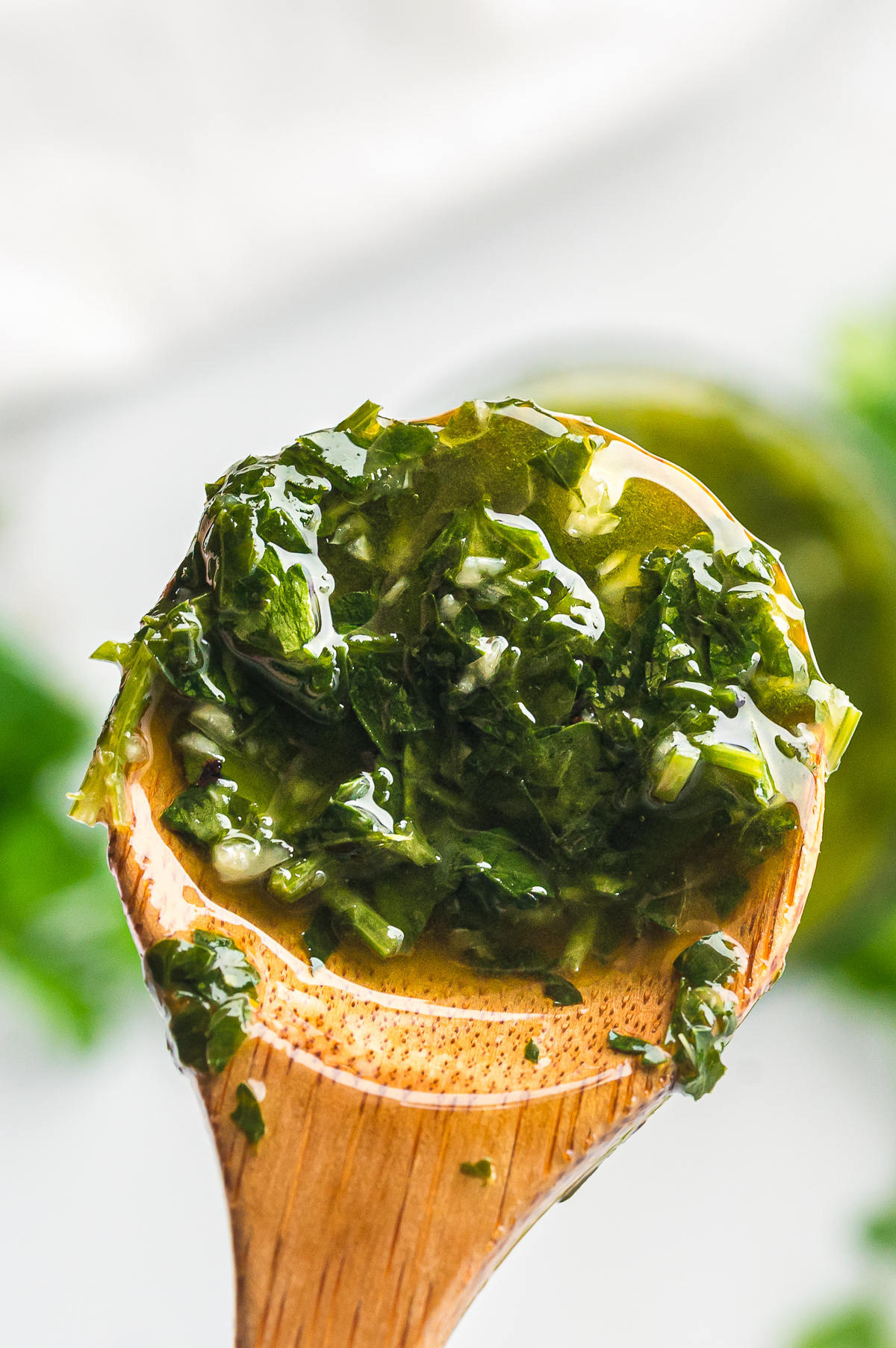 a upclose image of chimichurri sauce on a wooden spoon