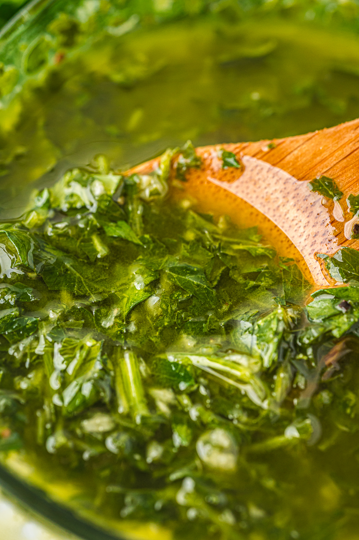 upclose image of a spoon in a bowl of chimichurri sauce