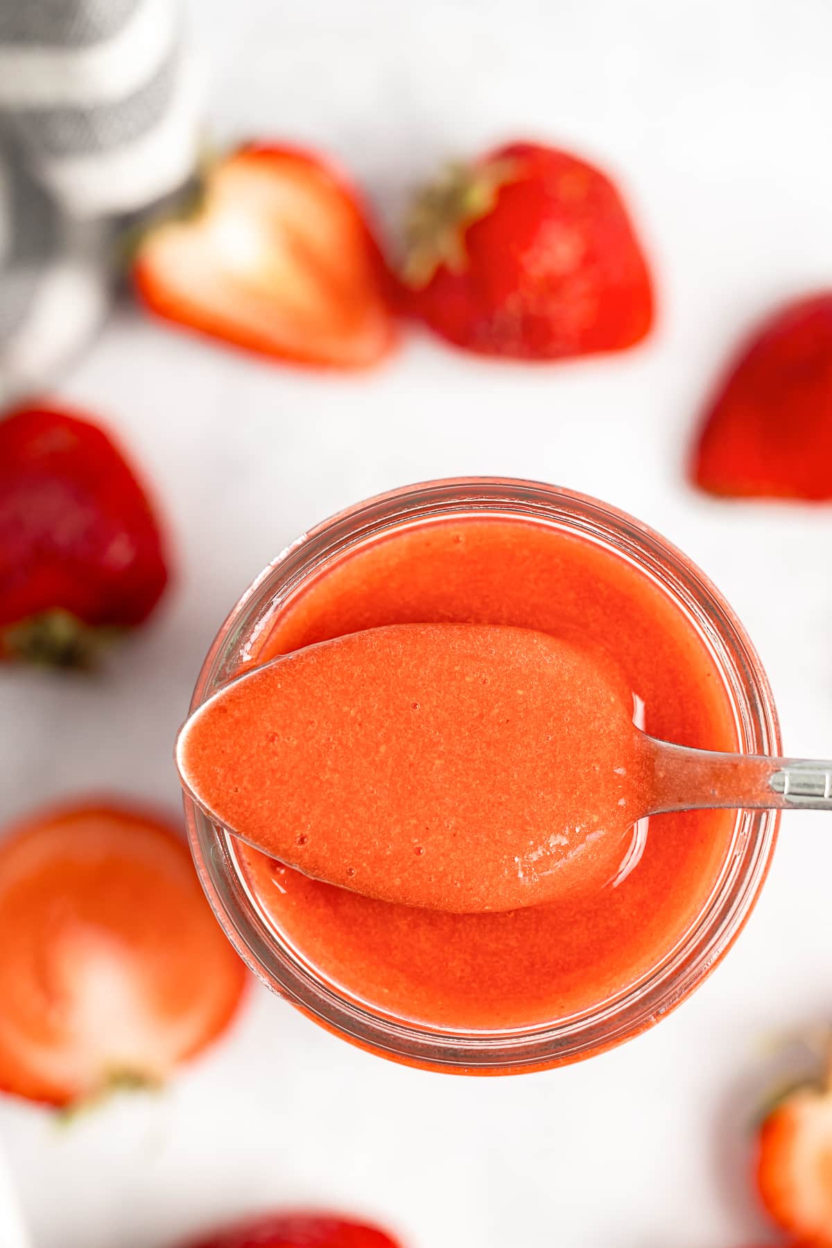 overhead image of a spoon in a mason jar with Strawberry Sauce Recipe