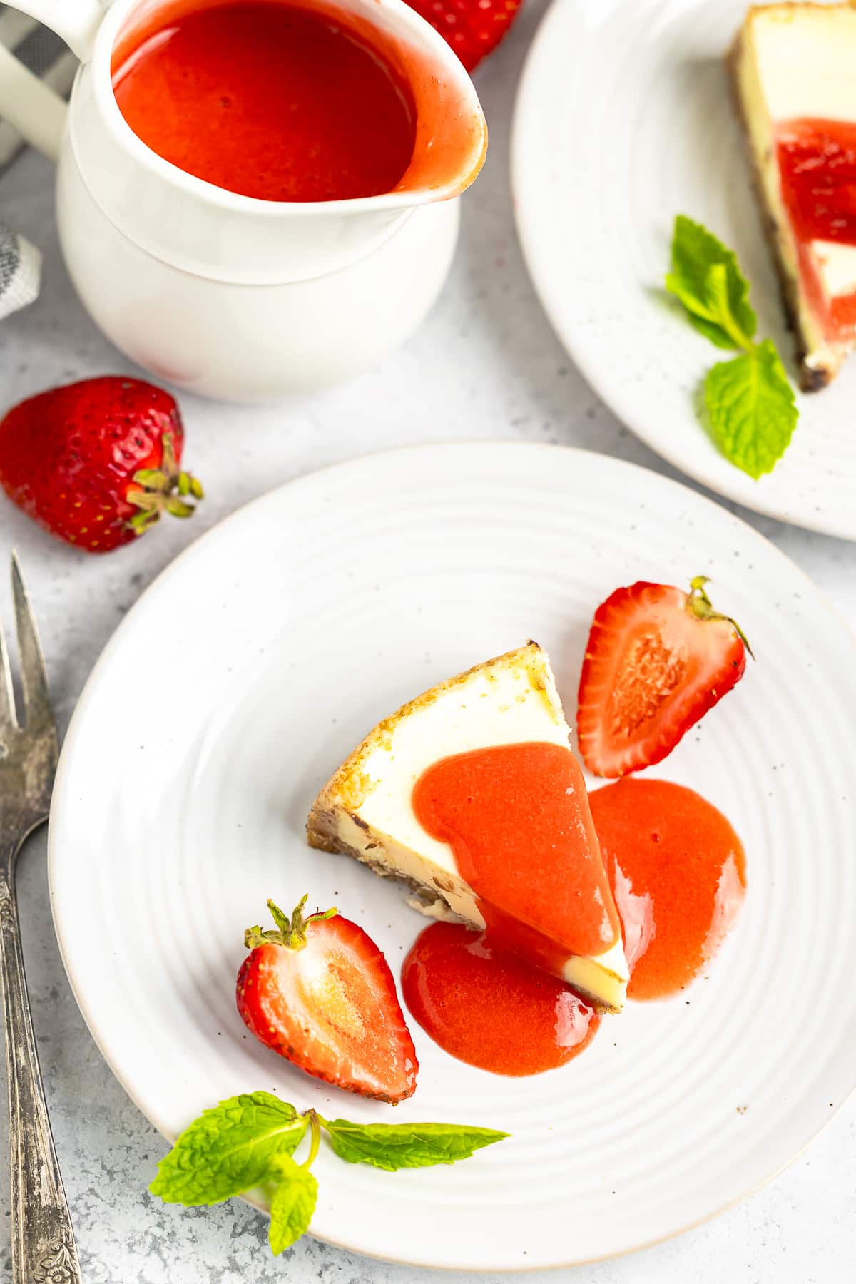 a piece of cheesecake with Strawberry Sauce Recipe on top, overhead image