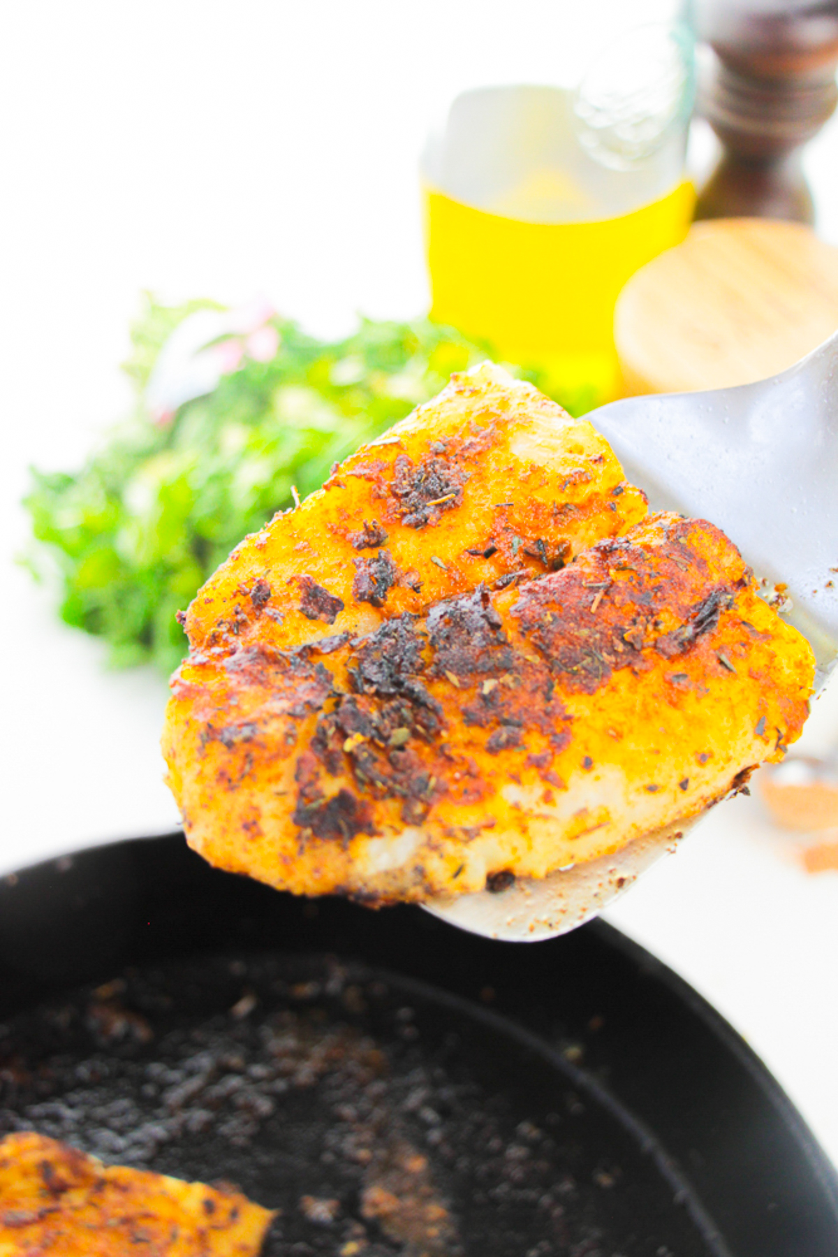 Blackened Catfish being held up in the air by a spatular