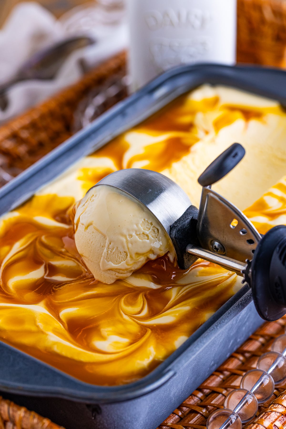 an ice cream scoop starting to scoop out some Butterscotch Ice Cream