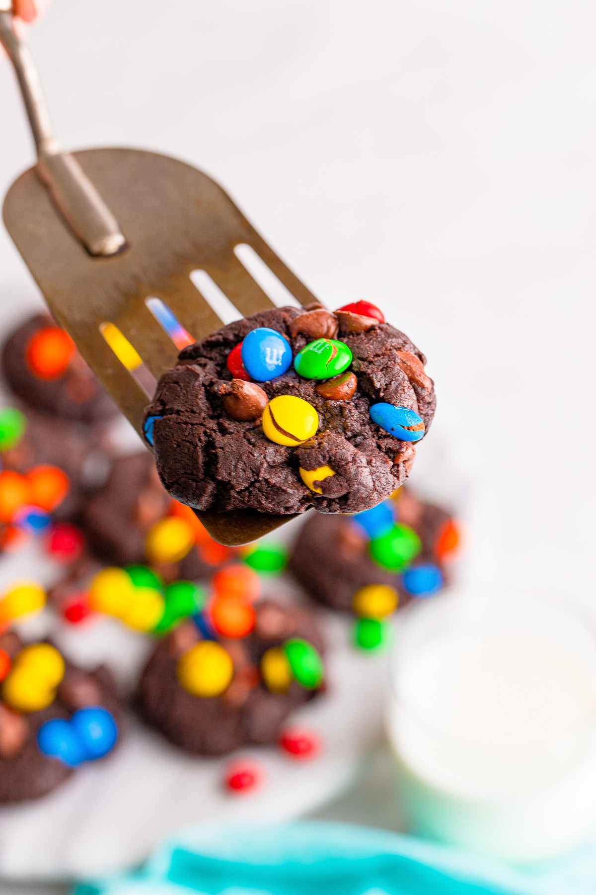 a spatula holding up Chocolate Chip M&M Cookies in air