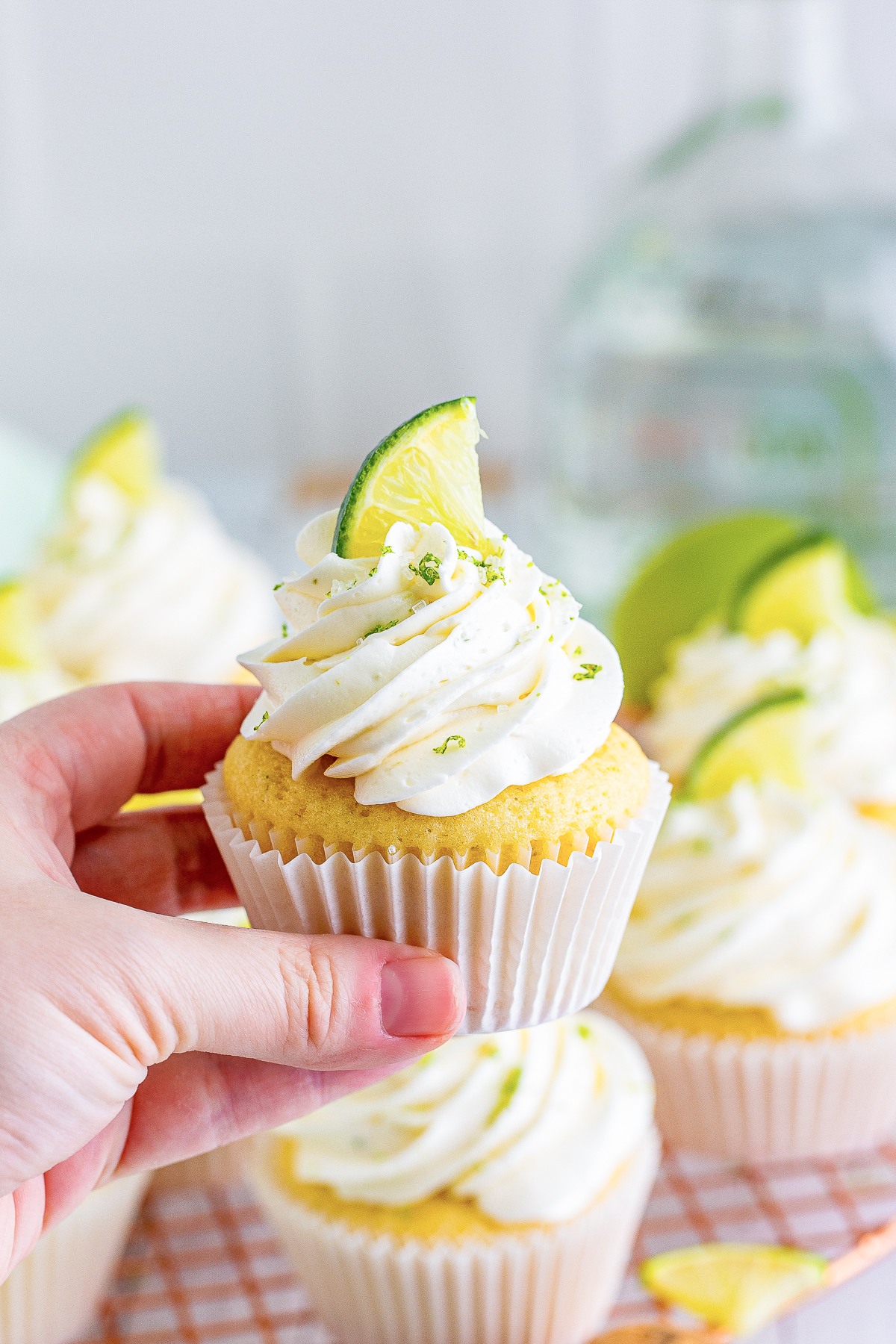a hand holding up Margarita Cupcakes in air