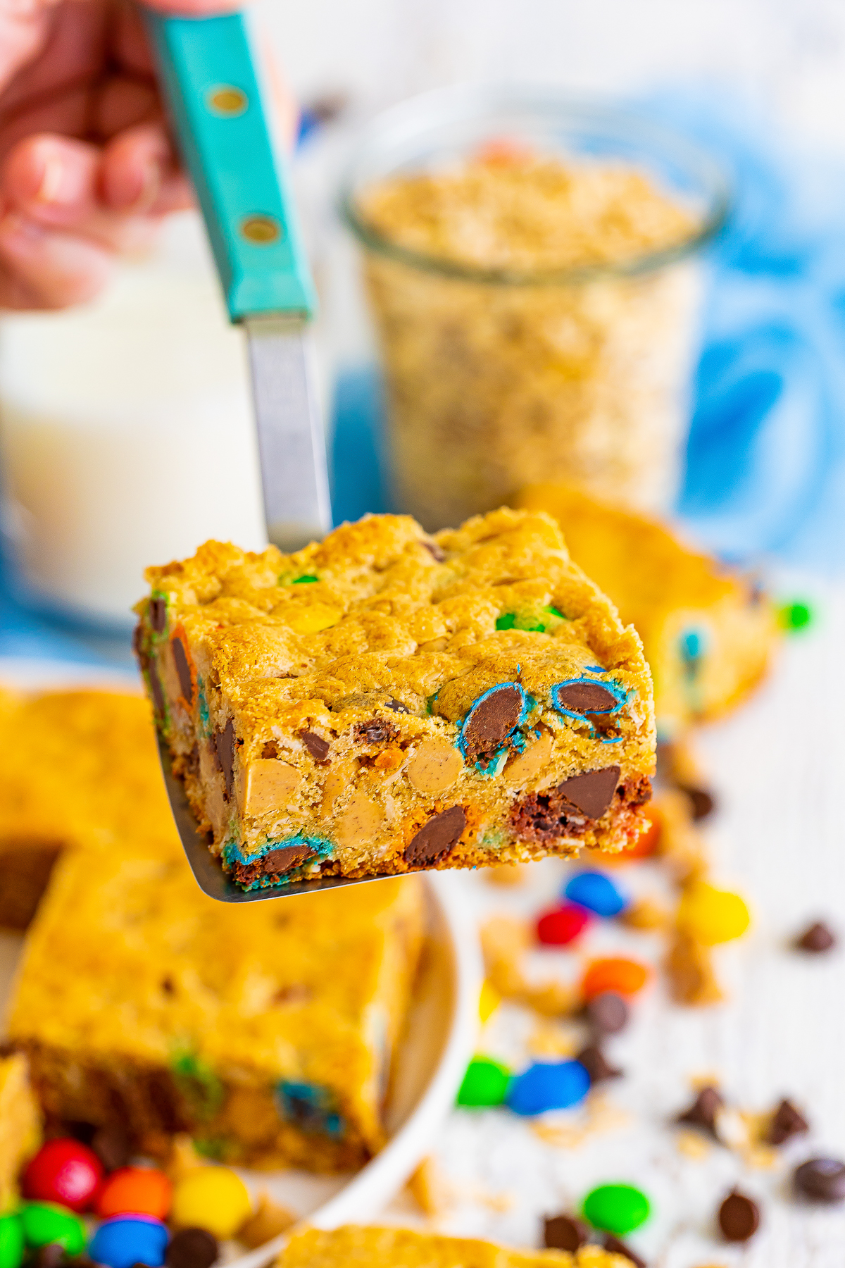 a spatula holding up Monster Cookie Bars in air