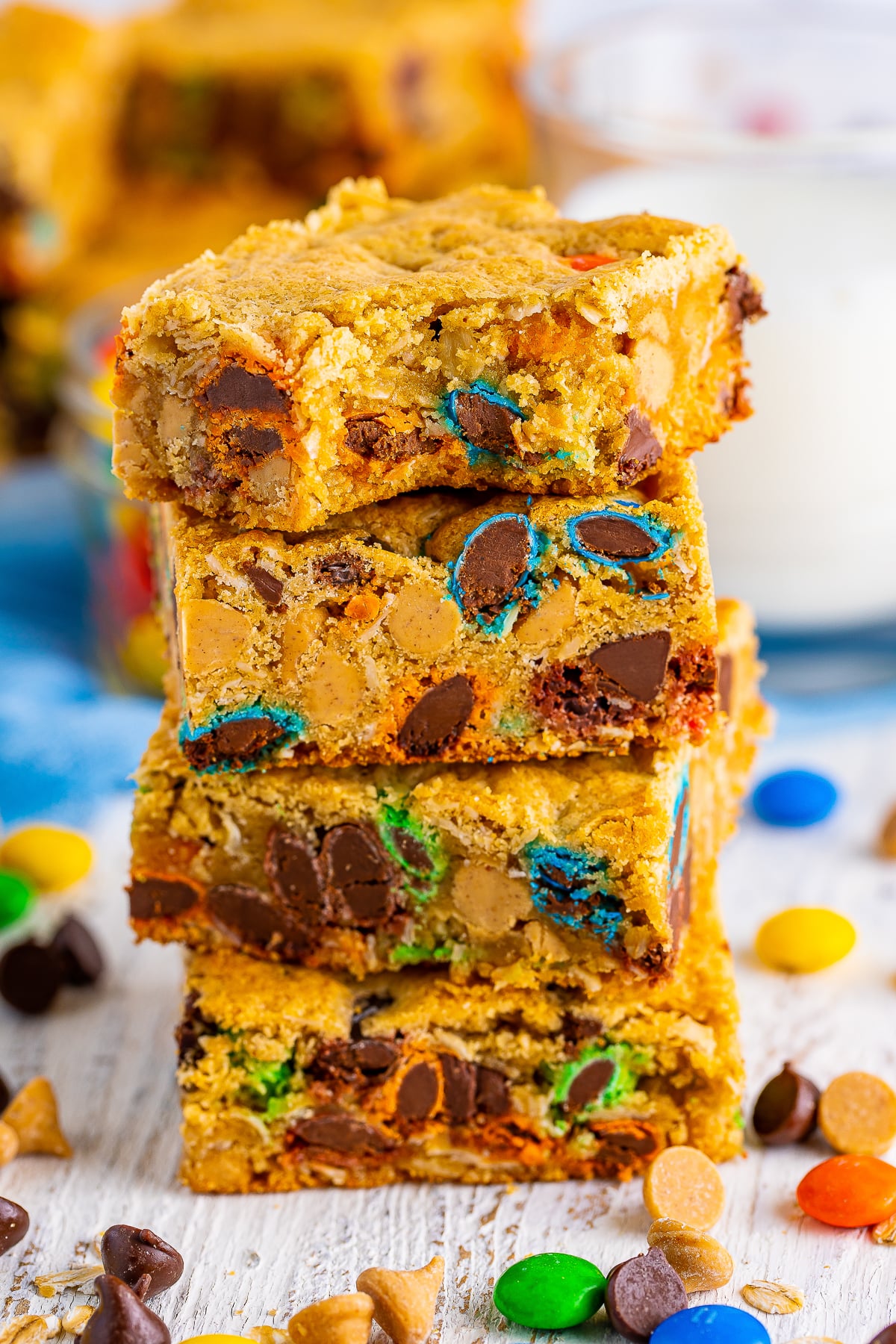 four Monster Cookie Bars stacked on top of each other, the one on top has a bite taken out