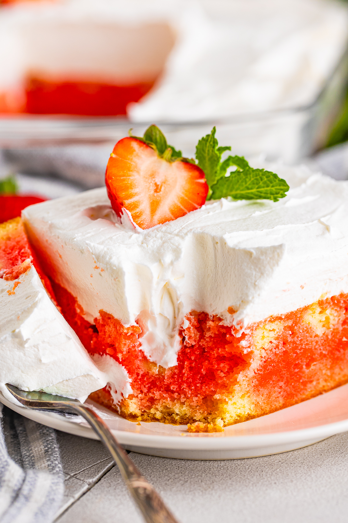 a slice of Jello Cake on a plate with a bite taken out