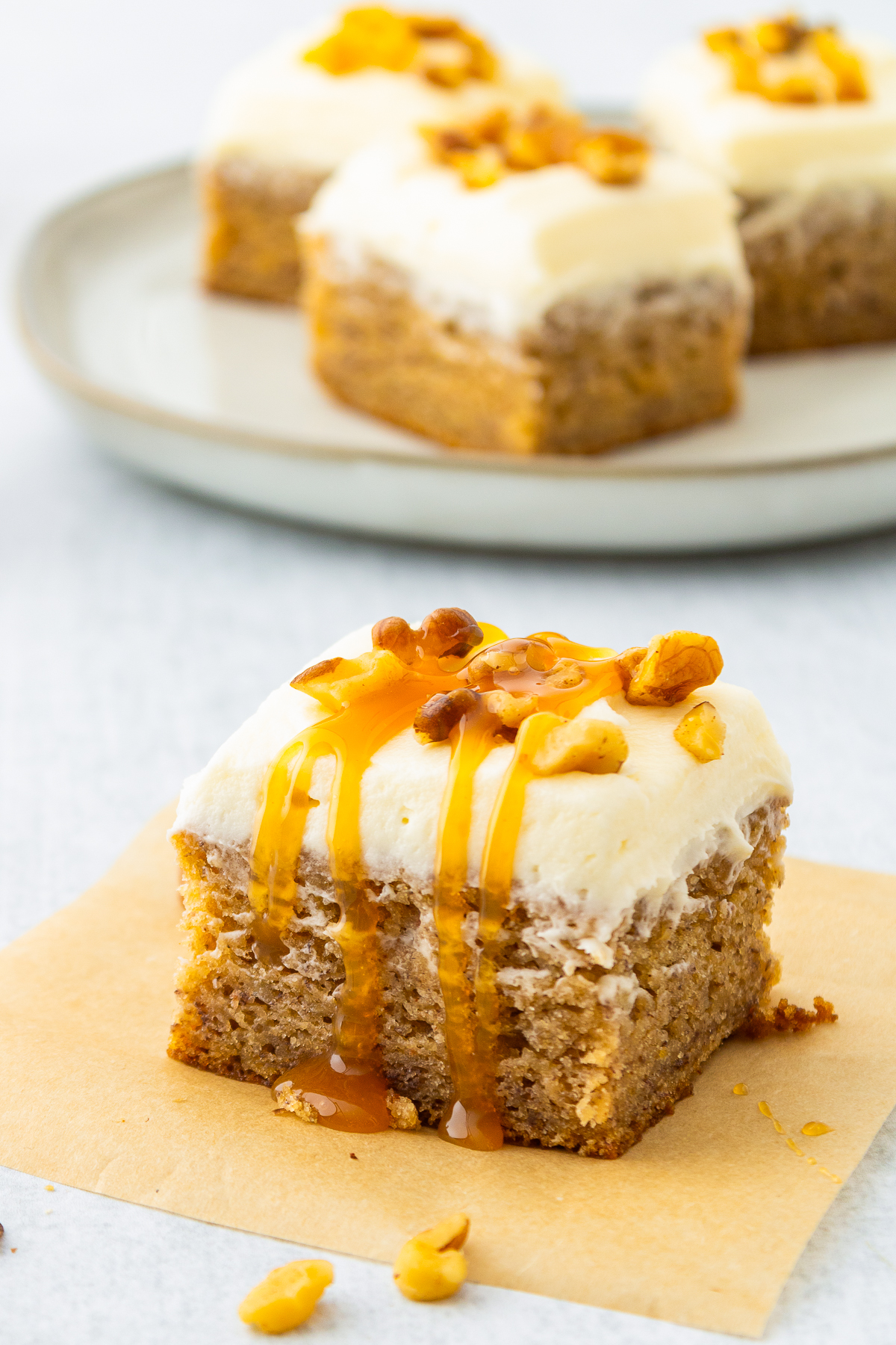 a piece of Banana Bars on parchment paper, caramel on top