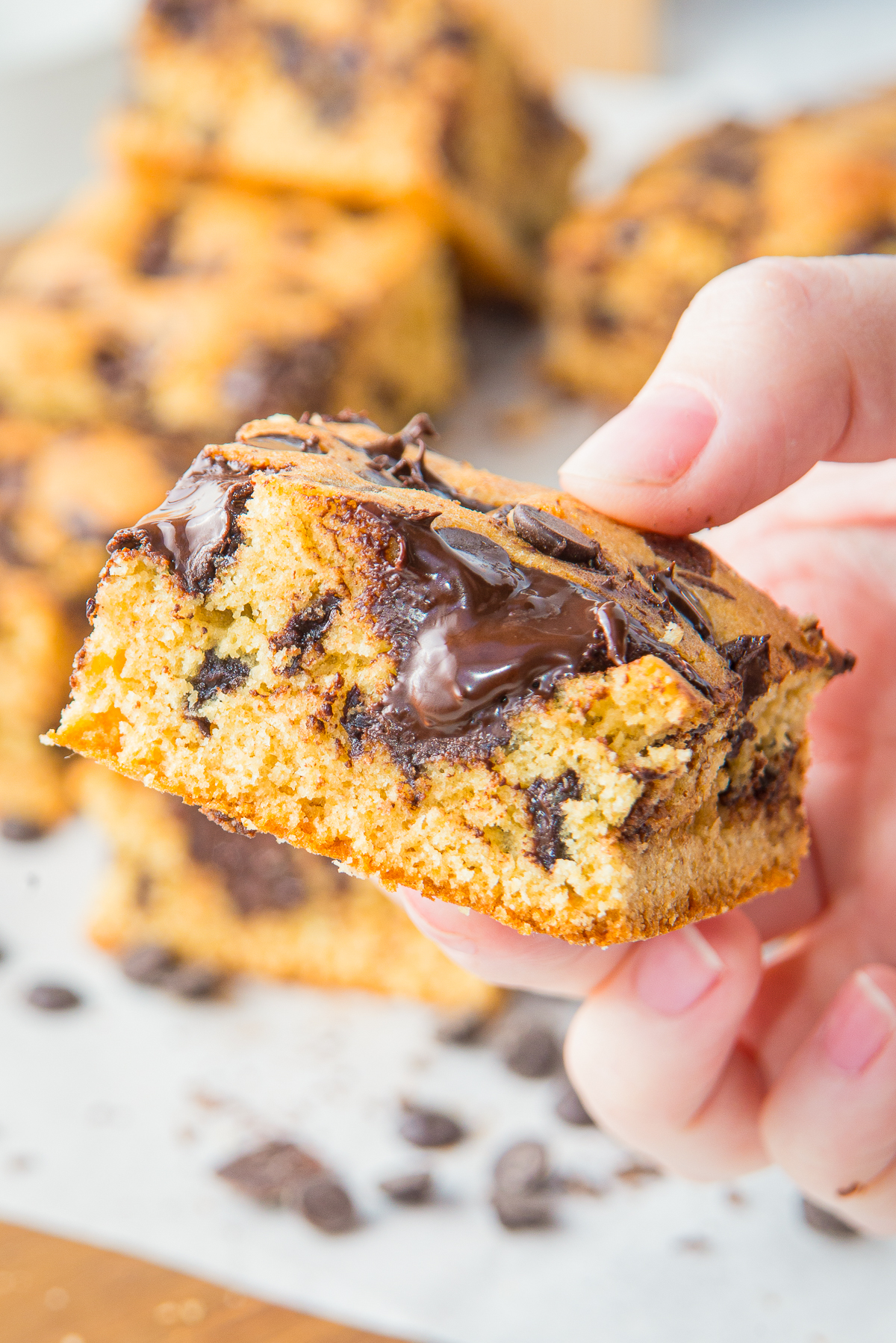 a hand holding up Chocolate Chip Cookie Bars in air