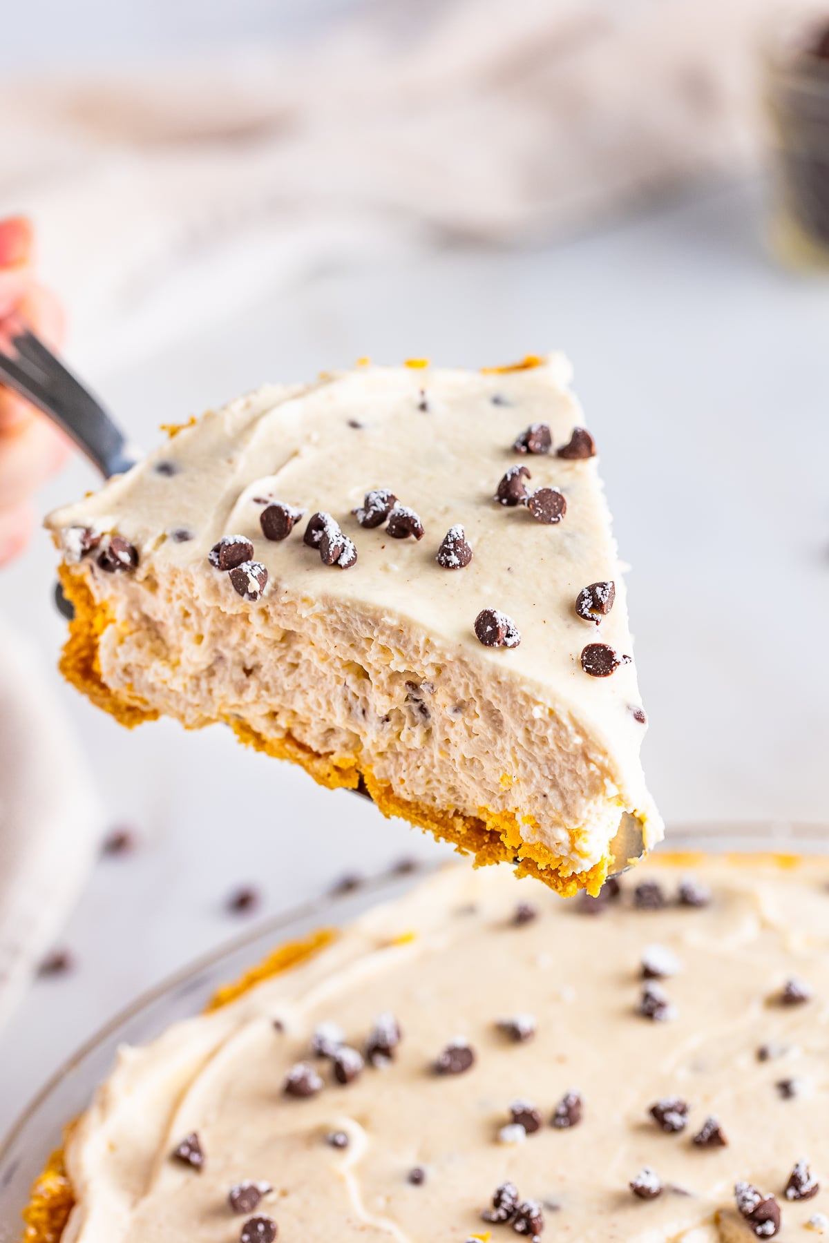 a slice of Cannoli Pie being held up in the air on a cake server