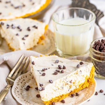 A whole no bake cannoli pie topped with mini chocolate chips and powdered sugar.