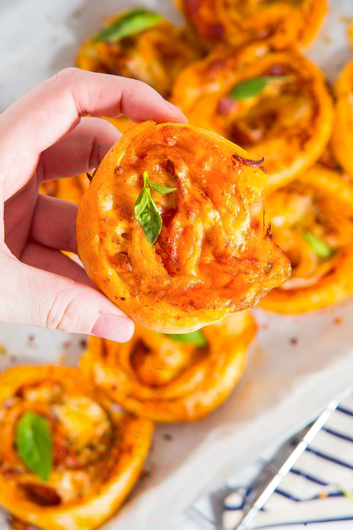 a hand holding up Pepperoni Rolls in air