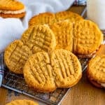 A stack of homemade nutter butter cookies on a wire rack.