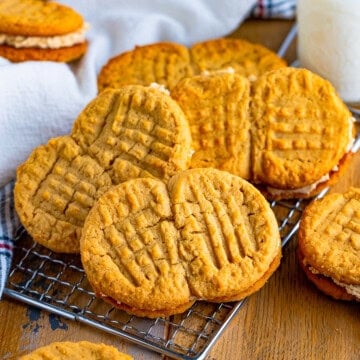 A stack of homemade nutter butter cookies on a wire rack.