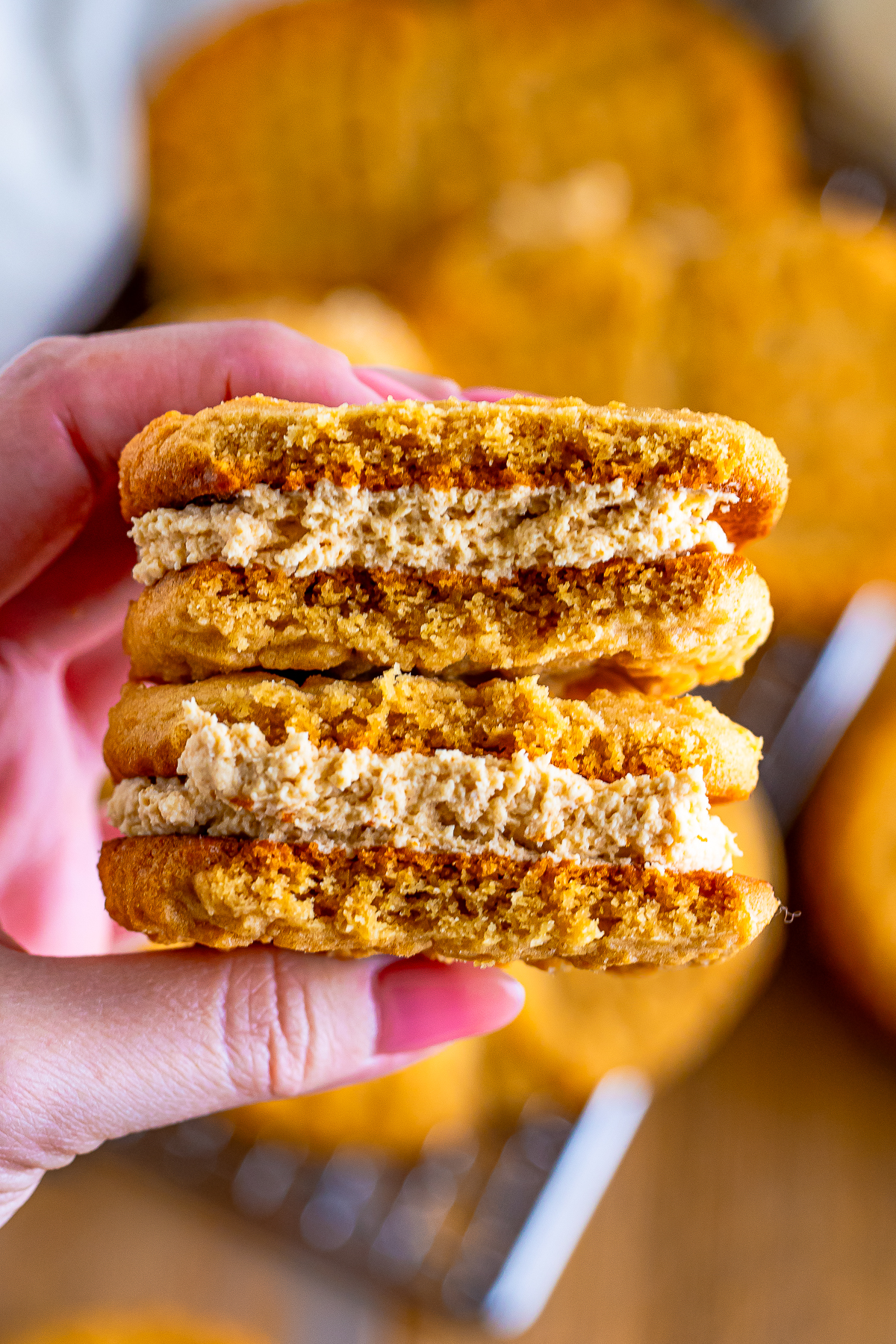 a hand holding up Nutter Butter Cookies that have been cut in half