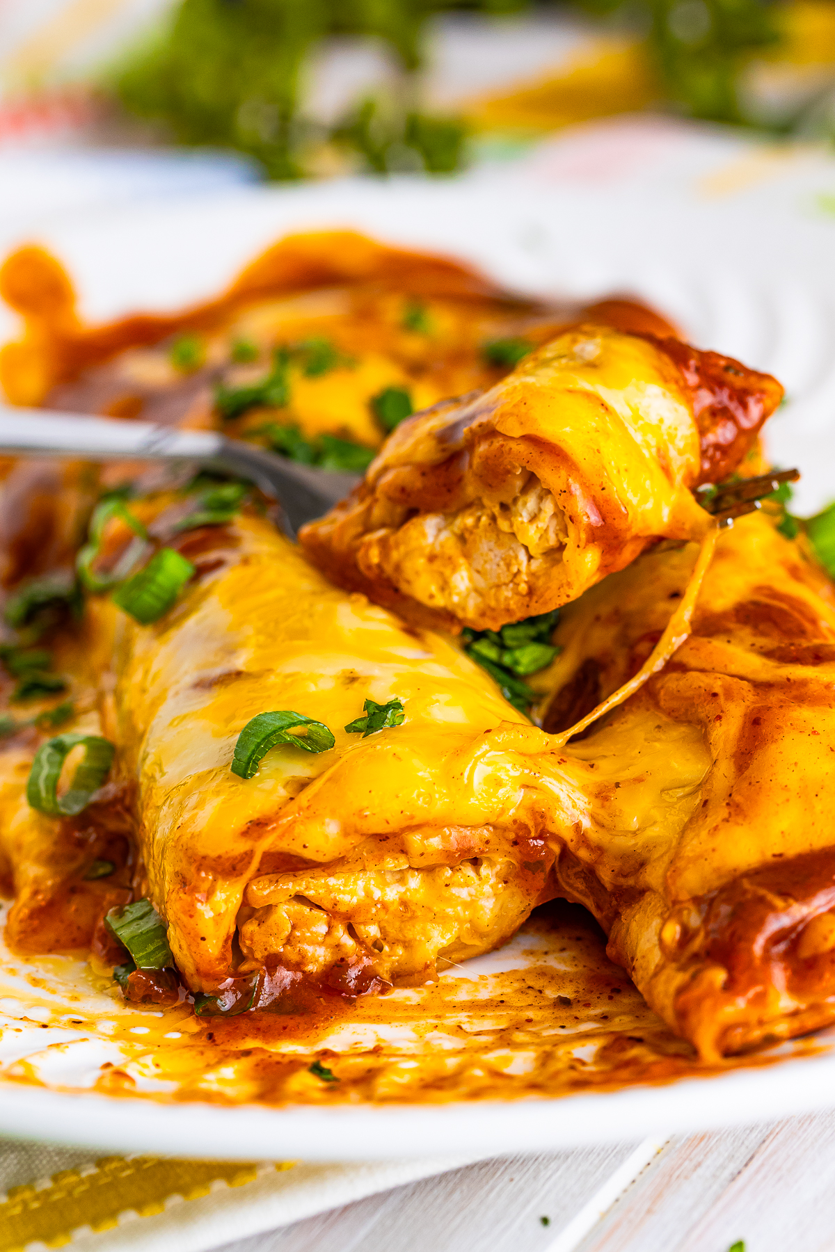 Rotisserie Chicken Enchiladas on a plate where one is cut in half